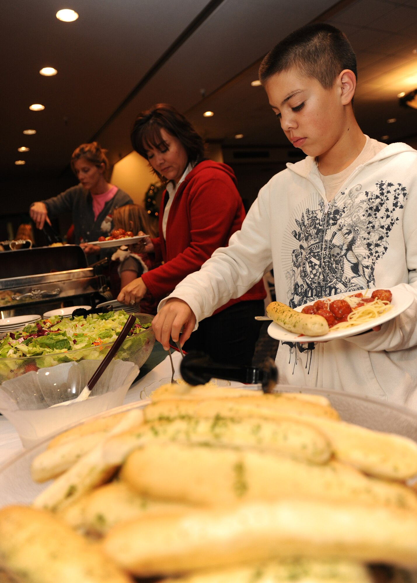 HOLLOMAN AIR FORCE BASE, N.M. -- Members of Team Holloman attending the Families Apart Dinner at the Desert Sands Enlisted Club line up to get dinner, Dec. 9. The Airman and Family Readiness Center holds a Families Apart Dinner at least every quarter for spouses and children of deployed members to get together and enjoy a dinner and crafts. The 49th Force Support Squadron hosted the Families Support Dinner in conjunction with the Deployment Expo. (U.S. Air Force photo by Senior Airman Michael Means)