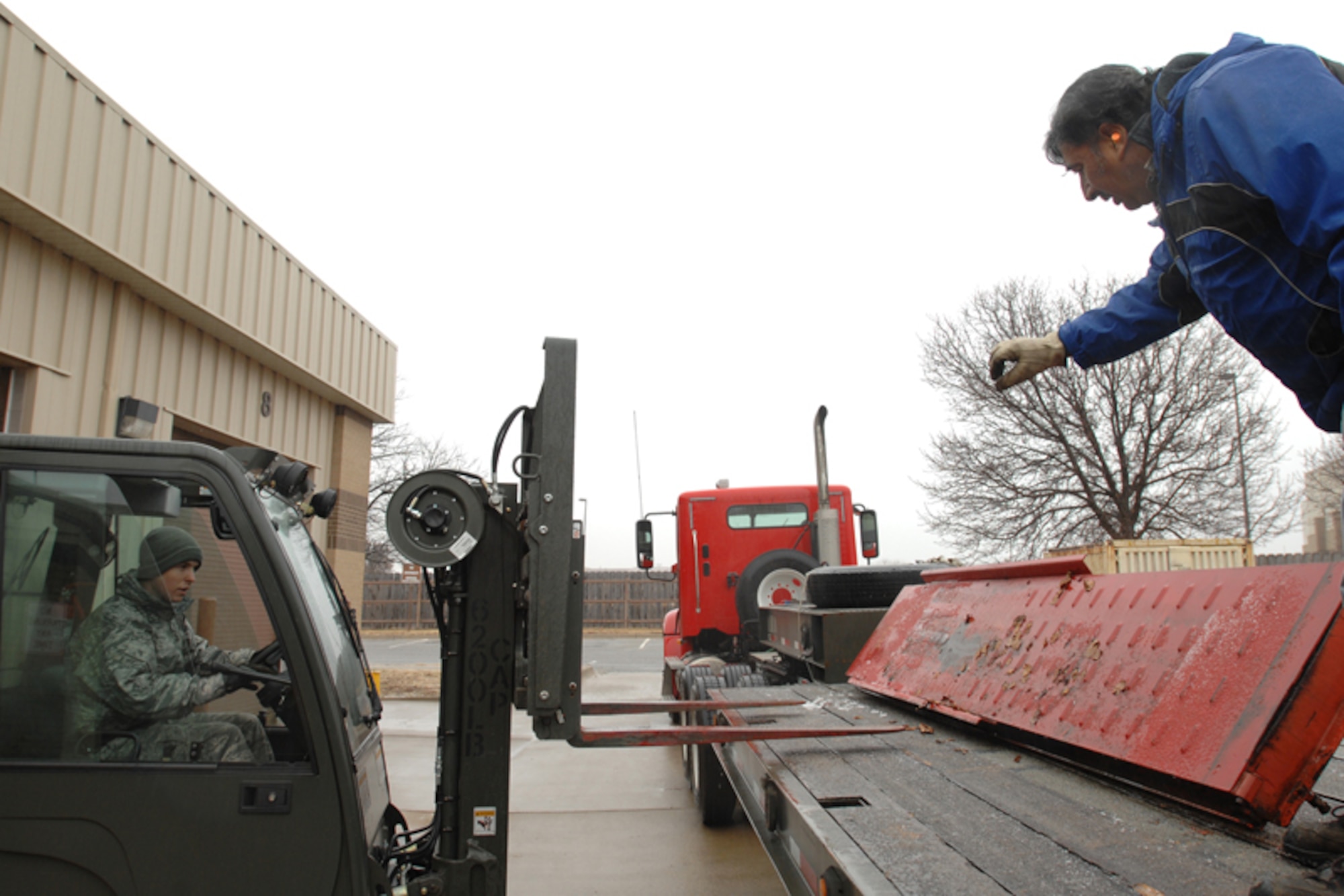 Airman 1st Class Aaron Geisler and Dennis Gonzalez, 22nd Logistics Readiness Squadron, load parts of a car lift on to a semi-trailer at McConnell Air Force Base, Kan., Dec. 8, 2009, before delivering the parts to Fort Riley Kan. Certain 22nd LRS vehicle operators are the only people on base with certification to drive semi-trailers. (U.S. Air Force photo/Staff Sgt. Jamie Train)