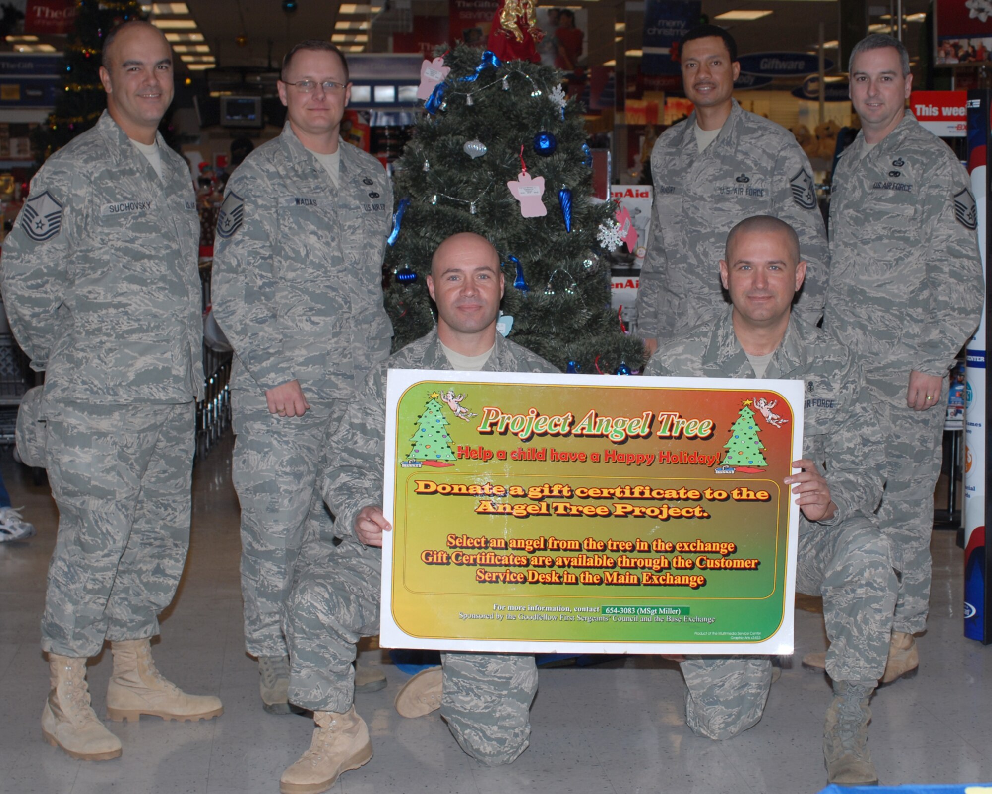 GOODFELLOW AIR FORCE BASE, Texas -- Members of the First Sergeants Council gather by the base exchange Christmas tree to raise awareness for Project Angel Tree, Dec. 8, 2009. The First Sergeants Council sponsors Project Angel Tree, an opportunity for Goodfellow members to assist others during the holiday season. The angels placed on the tree provide gift card suggestions for families needing assistance. (U.S. Air Force photo/Staff Sgt. Laura R. McFarlane)