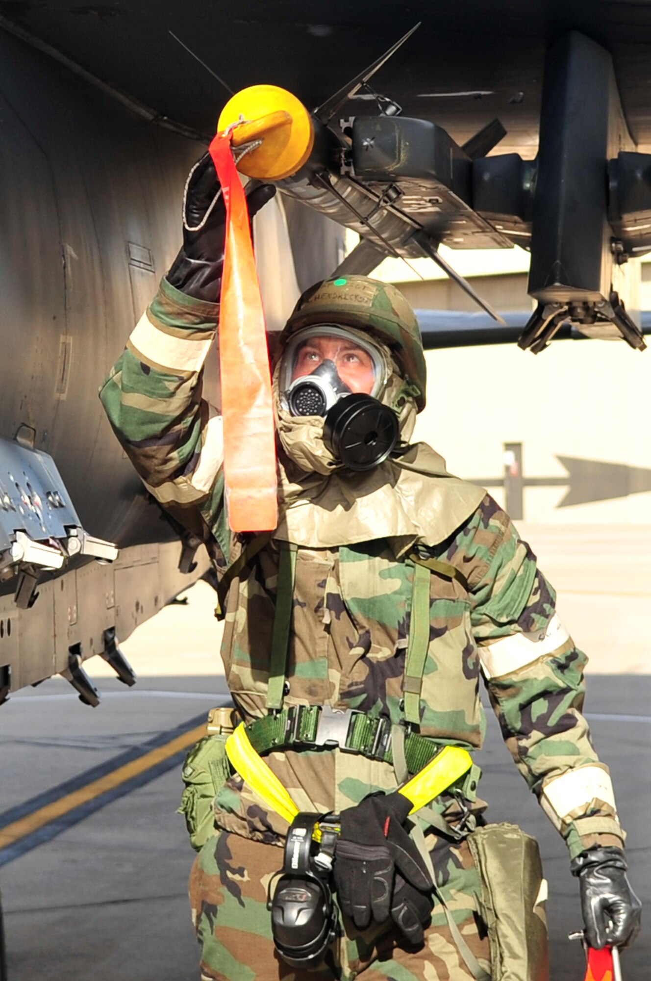 Staff Sgt. Adam Hendrickson, 4th Aircraft Maintenance Squadron, removes the protective cap from a smart weapon on an F-15E Strike Eagle from Seymour Johnson Air Force Base, N.C., Dec. 10, 2009. Ground and aircrews performed their missions in protective gear as part of an operational readiness exercise. During the week-long exercise, 4th Fighter Wing Airmen tested their ability to execute wartime taskings and generate combat sorties under simulated wartime conditions. (U.S. Air Force photo/Airman 1st Class Rae Perry)