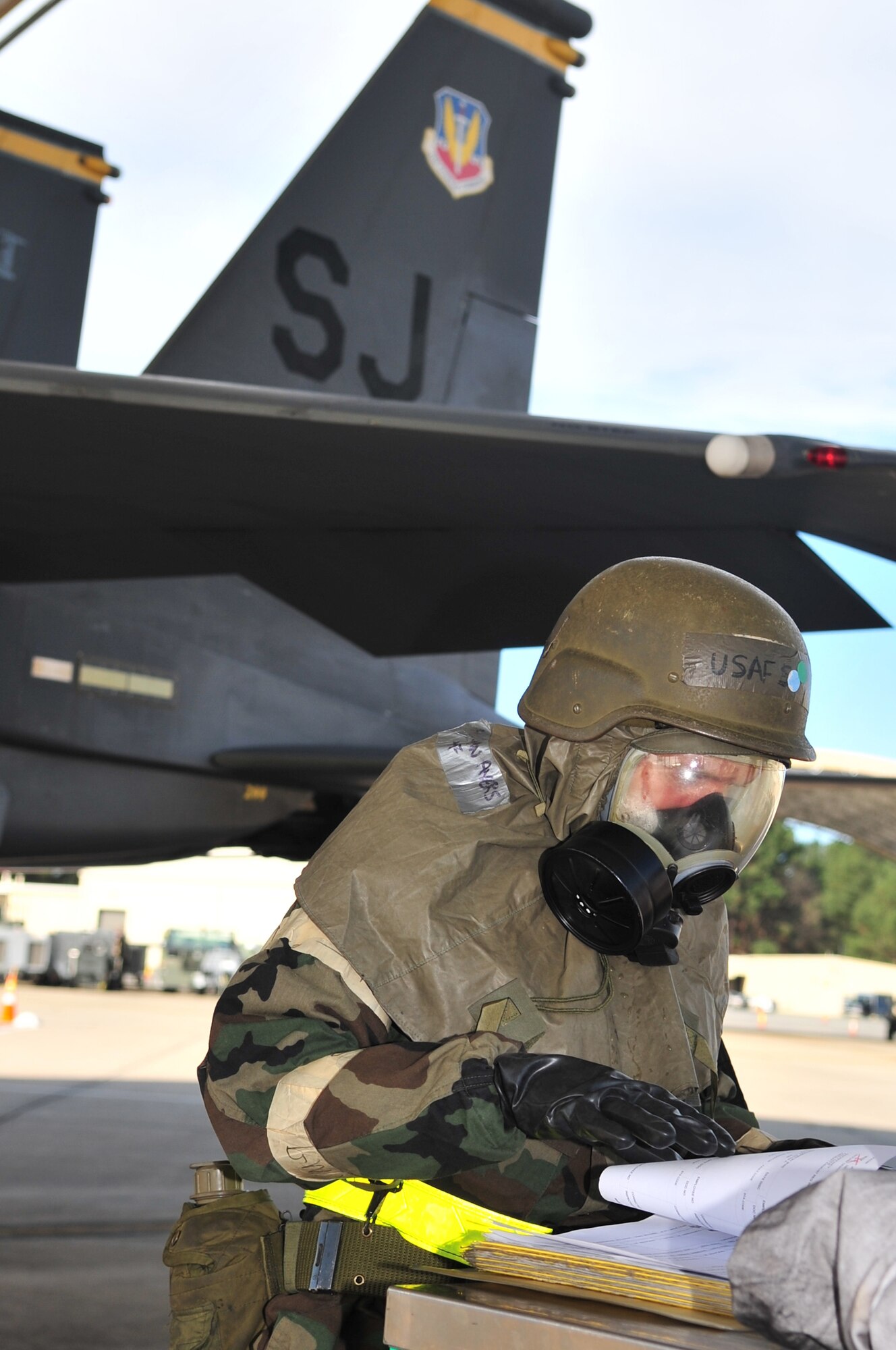 Senior Airman Phillip Butche, 4th Aircraft Maintenance Squadron, looks over the log for the F-15E Strike Eagle behind him to see what he and his crew need to accomplish before the aircraft is crew ready during an operational readiness exercise on Seymour Johnson Air Force Base, N.C., Dec. 10, 2009. Flightline Airmen are evaluated on how well they prepare a jet for take-off in mission-oriented protective posture level four. (U.S. Air Force photo/Airman 1st Class Rae Perry)