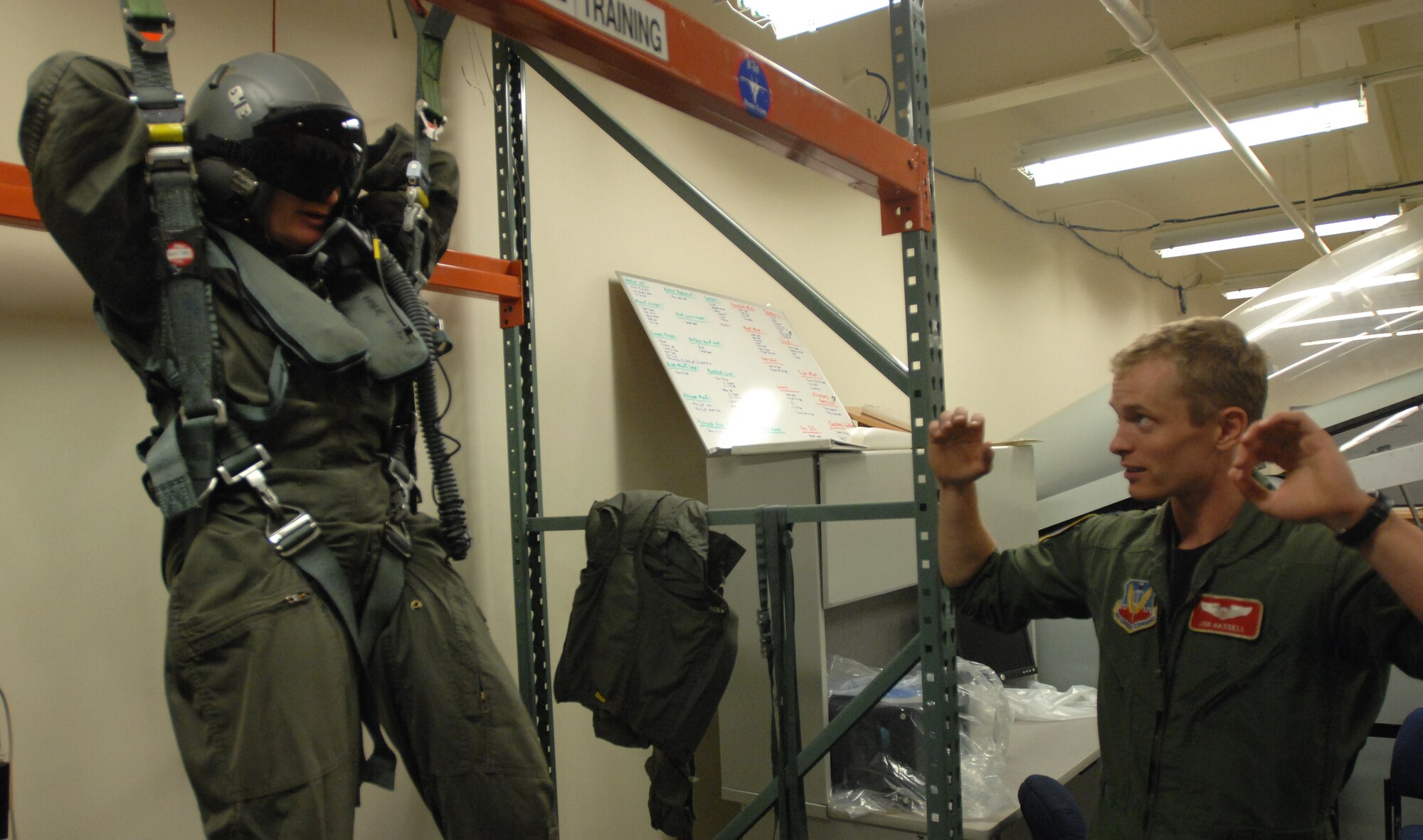 LANGLEY AIR FORCE BASE, Va. -- Capt. Jon Hassell, 71st Fighter Squadron standard evaluation chief, shows the basic techniques of controlling a parachute to Molly Ward, Hampton mayor, in preparation for her orientation flight Dec. 10. The 1st Fighter Wing granted Mayor Ward the orientation flight to familiarize her with the the Langley mission. (U.S. Air Force photo/Senior Airman Scott Aldridge)
