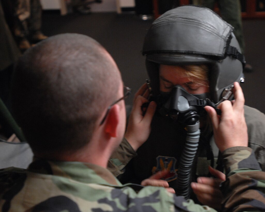 LANGLEY AIR FORCE BASE, Va. -- Staff Sgt. Brett Burchfield, 71st Fighter Squadron aircrew flight equipment craftsman, places a flight mask on Molly Ward, Hampton mayor, in preparation for her orientation flight Dec. 10. The 1st Fighter Wing granted Mayor Ward the orientation flight to familiarize her with the the Langley mission. (U.S. Air Force photo/Senior Airman Scott Aldridge)
