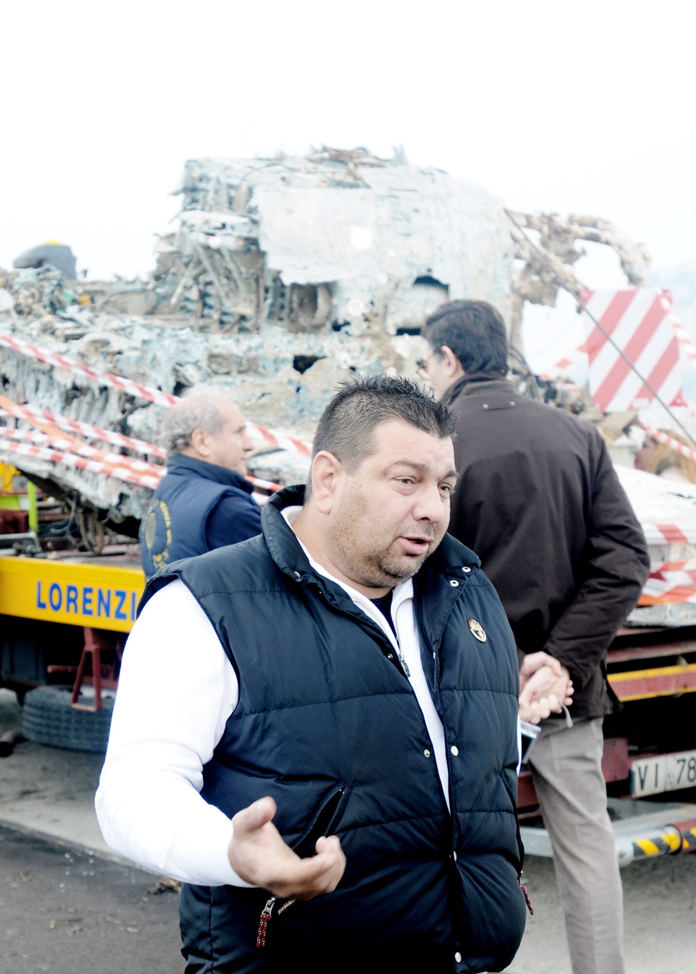 Italian fisherman Filippo Salvagno talks in front of aircraft wreckage, believed to be a World War II Army Air Force P-47 Thunderbolt fighter, that crashed into the Adriatic Sea in the mid-1940s Nov. 14, 2009, at the Chioggia Lagoon in Italy. Mr. Salvagno recovered a large section of the aircraft during a fishing expedition in May 2009. (U.S. Air Force photo/Airman LaVel D. Sterling)