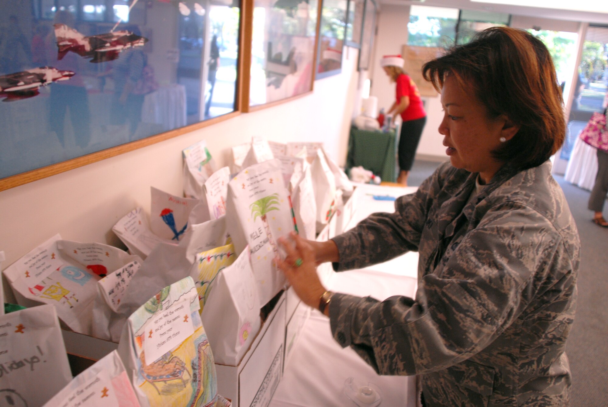 HICKAM AIR FORCE BASE, Hawaii - Lt. Col. Tracy Saiki, 15th Airlift Wing public affairs, organizes bags of cookies to be picked up by 15th Airlift Wing First Sergeants during the annual Cookie Caper here, Dec. 10. Every year airmen living in the dorms recieve a bag of homemade cookies put together by volunteers. More than 398 airmen will recieve a bag of goodies this year. (U.S. Air Force photo/Senior Airman Gustavo Gonzalez)