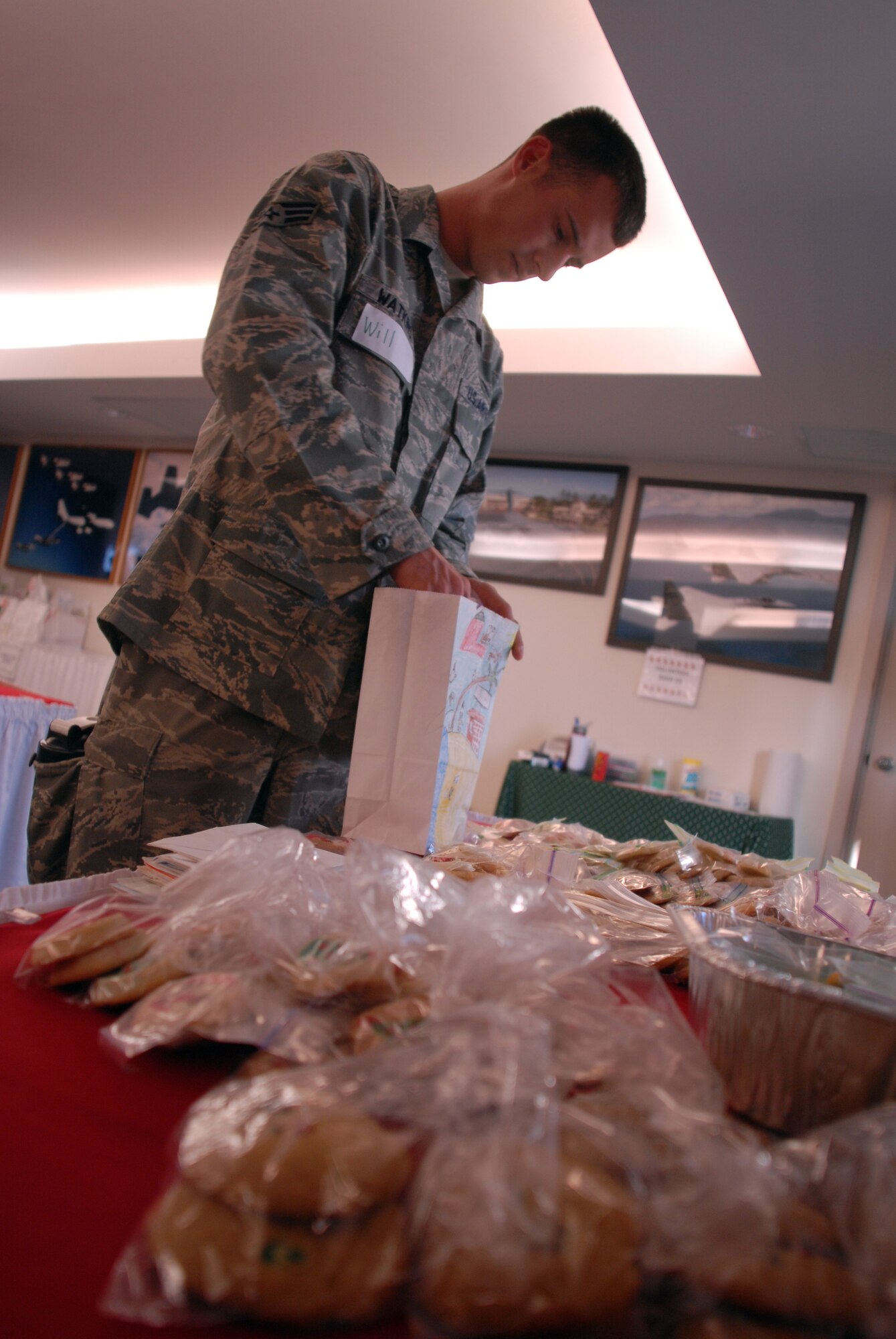 HICKAM AIR FORCE BASE, Hawaii - Senior Airman Will Watkins, 15th Communications Squadron, organizes bags of cookies to be picked up by 15th Airlift Wing First Sergeants during the annual Cookie Caper here, Dec. 10. Every year airmen living in the dorms recieve a bag of homemade cookies put together by volunteers. More than 398 airmen will recieve a bag of goodies this year. (U.S. Air Force photo/Senior Airman Gustavo Gonzalez)