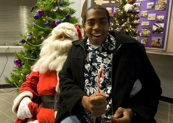 Aaron G. Lewis, 95th Air Base Wing Public Affairs videographer, earns a candy cane from Santa Claus. Not everyone will be so lucky however, during the 95th ABW Holiday party Dec. 16. (U.S. Air Force photo)