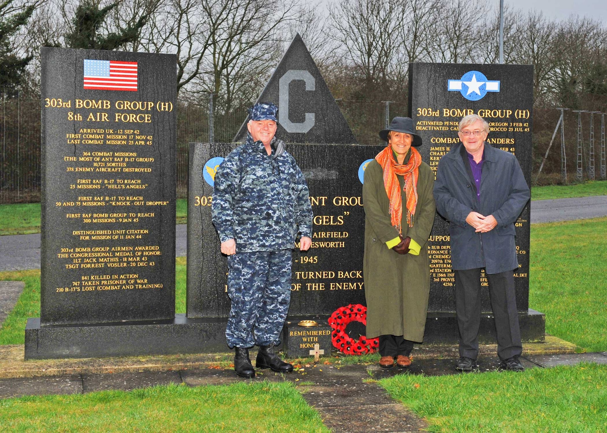 Mr. Ken Ellis, Editor of FLYPAST Magazine, a British aviation journal devoted to heritage aircraft and the preservation and return to flight of warbirds, joins his wife, Pam, a former barnstorming wingwalker, and JAC Deputy Commander Navy Capt. Henry J. "Harry" Babin at the 303rd Bomb Group (Heavy) Memorial. (U.S. Air Force photo by Staff Sgt. Javier Cruz)