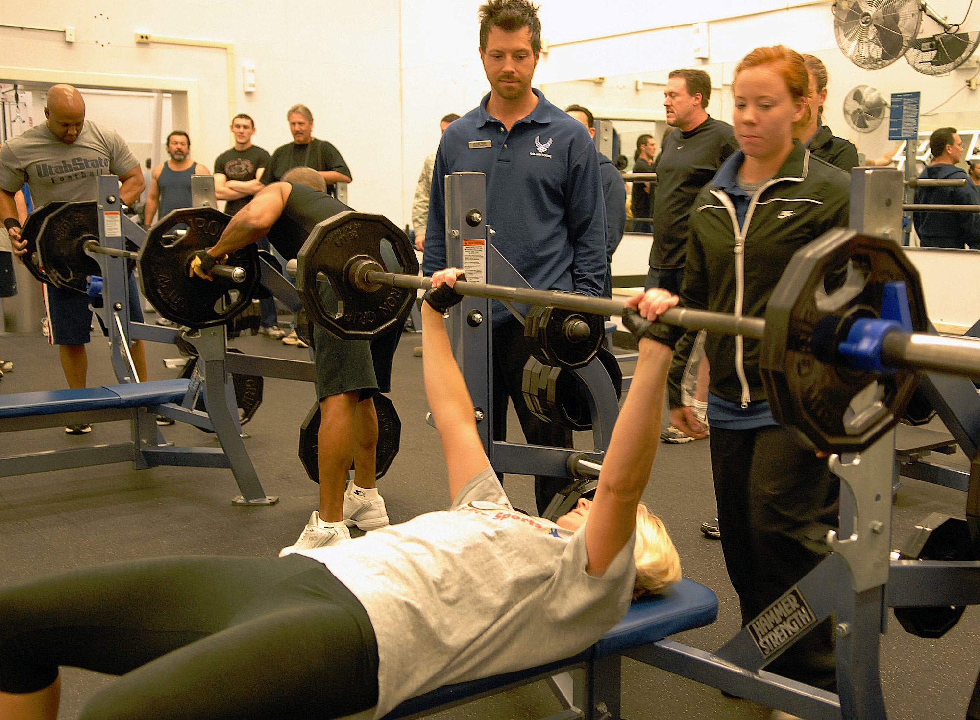 Katarina Zuber performs her first lift attempt as her spotters look on Dec. 3 at the Rosburg Fitness Center's fourth quarter bench press competition.  Mrs. Zuber finished first in the women's category by lifting 75.2 percent of her body weight. (Air Force photo/2nd Lt Belena Marquez)