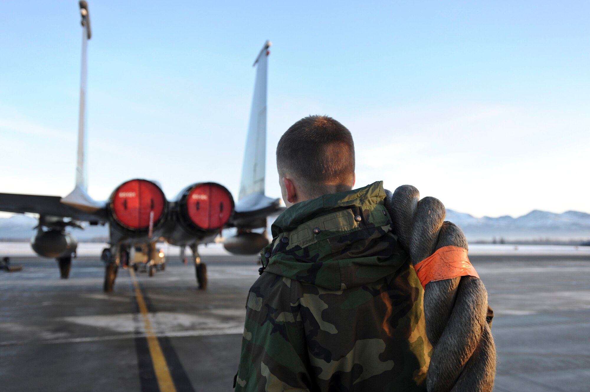 ELMENDORF AIR FORCE BASE, Alaska – Senior Airman Sean Delaney, 19th Aircraft Maintenance Unit electrical and environmental specialist, helps guide an Elmendorf F-15 Eagle back into place, Dec. 7, after it was moved earlier to clear snow. Elmendorf’s maintainers have to take extra precaution in the winter due to slippery conditions.  (U.S. Air Force photo/Airman 1st Class Christopher Gross)