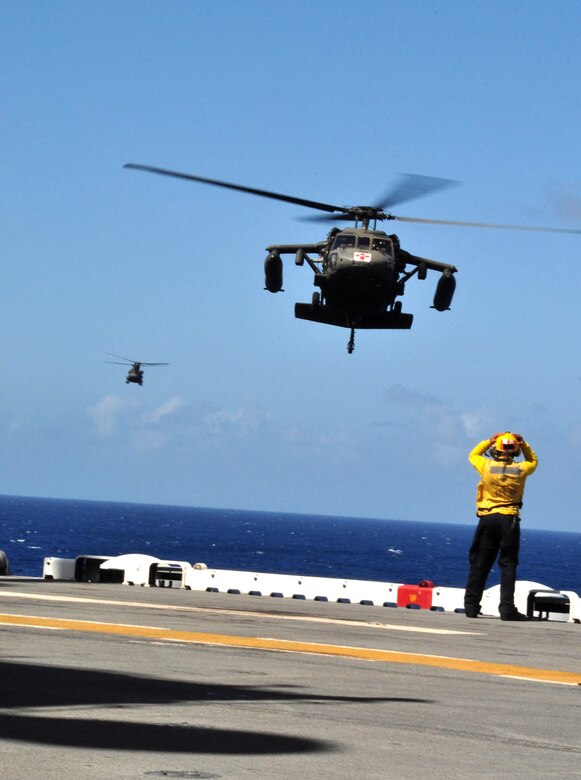 A U.S. Army HH-60 Blackhawk and CH-47 Chinook prepare to land on the flight deck of the U.S.S. Wasp mulitipurpose amphibious assault ship during deck landing qualification training Dec. 8, 2009. Forty-six U.S. Army aircrew members conducted the training with the Chinook and Blackhawk helicopters, staying aboard the Wasp while underway in the Caribbean Sea. (U.S. Air Force photo/Tech. Sgt. Mike Hammond).