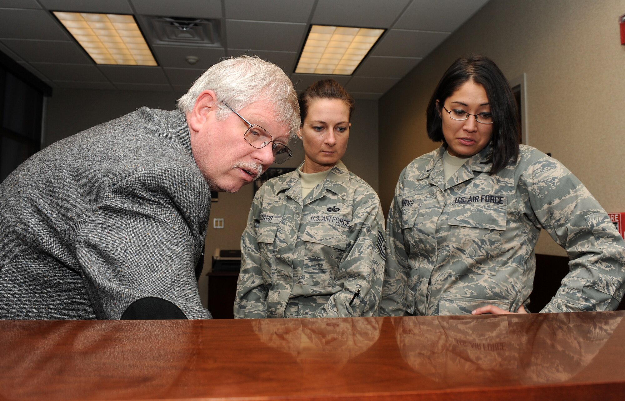 LANGLEY AIR FORCE BASE, Va. --  David Moorhouse, 1st Mission Support Group Joint-Basing office coordinator, shows Tech. Sgt. Rachel Staub, 1st Fighter Wing Command Chief's assistant, and 1st Lt. Karena Stevens, 1st Fighter Wing executive officer, how to utilize the upgraded phone system in the new 633rd Air Base Wing's building Dec. 9.  The 633d ABW will be holding its activation ceremony Jan. 7.  (U.S. Air Force photo/Senior Airman Zachary Wolf)