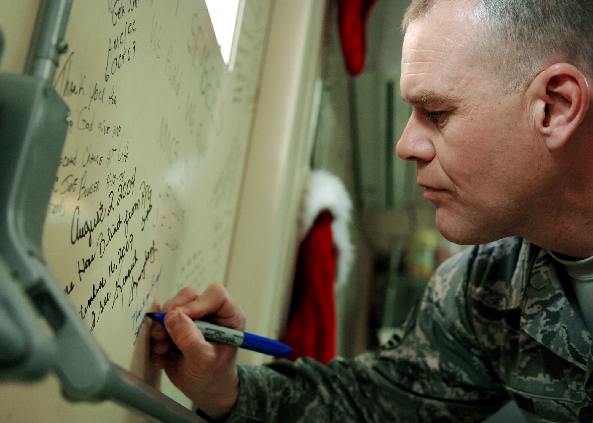 Chief Master Sgt. of the Air Force James A. Roy signs the warrior wall Dec. 4, 2009 at the Air Force Theater Hospital at Jooint Base Balad, Iraq. During his first visit to JB Balad as the chief master sergeant of the Air Force, Chief Roy toured various locations on the base and mentored Airmen during an Airman's call. (U.S. Air Force photo/Senior Airman Christopher Hubenthal)
