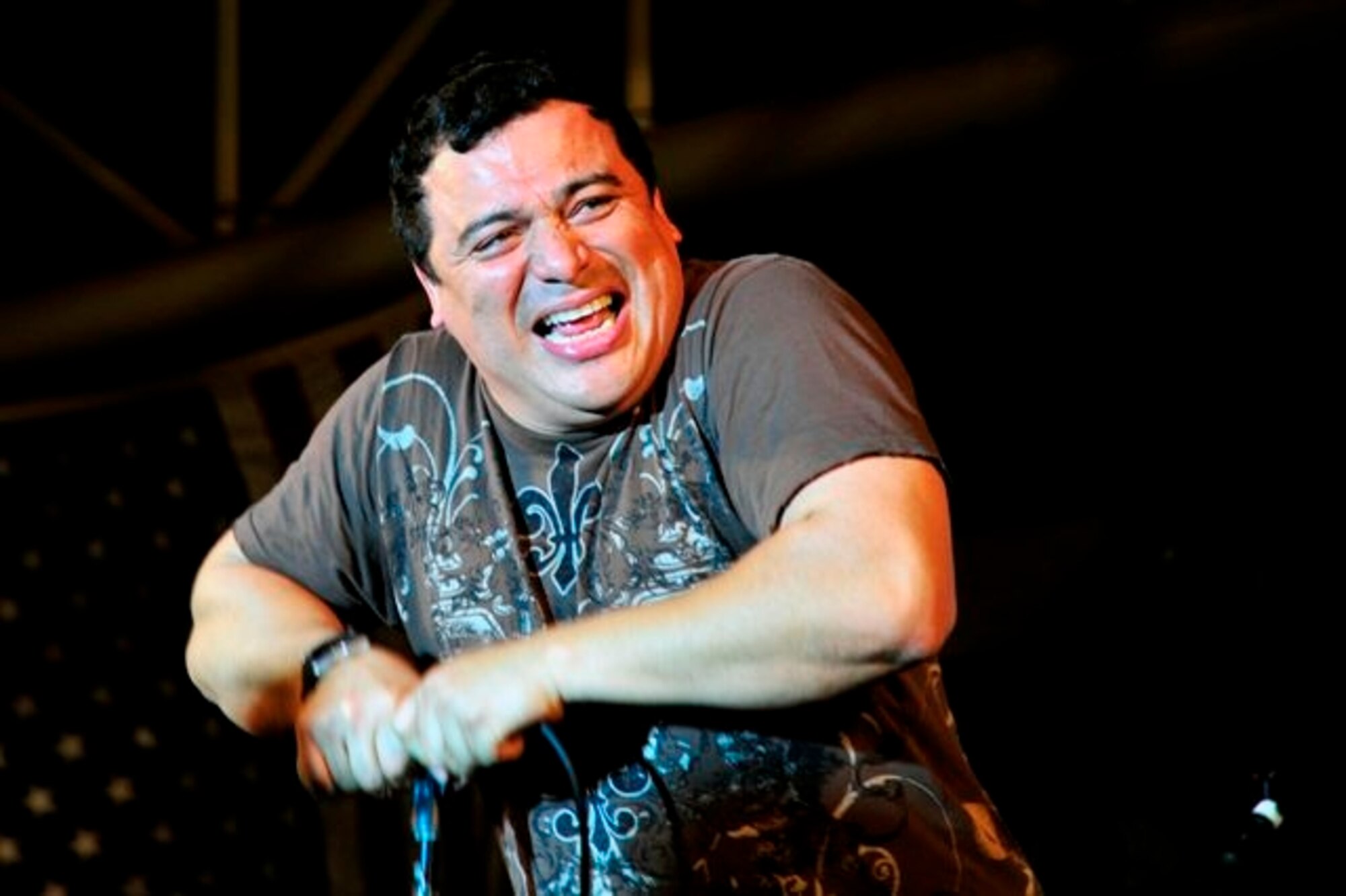 SOUTHWEST ASIA—Comedian Carlos Mencia performed for more than 1,000 deployed Airmen and Soldiers at the 380th Air Expeditionary Wing recently. This was the artist’s fourth time to the deployed environment. (U.S. Air Force Photo/Tech Sgt. Charles Larkin Sr)