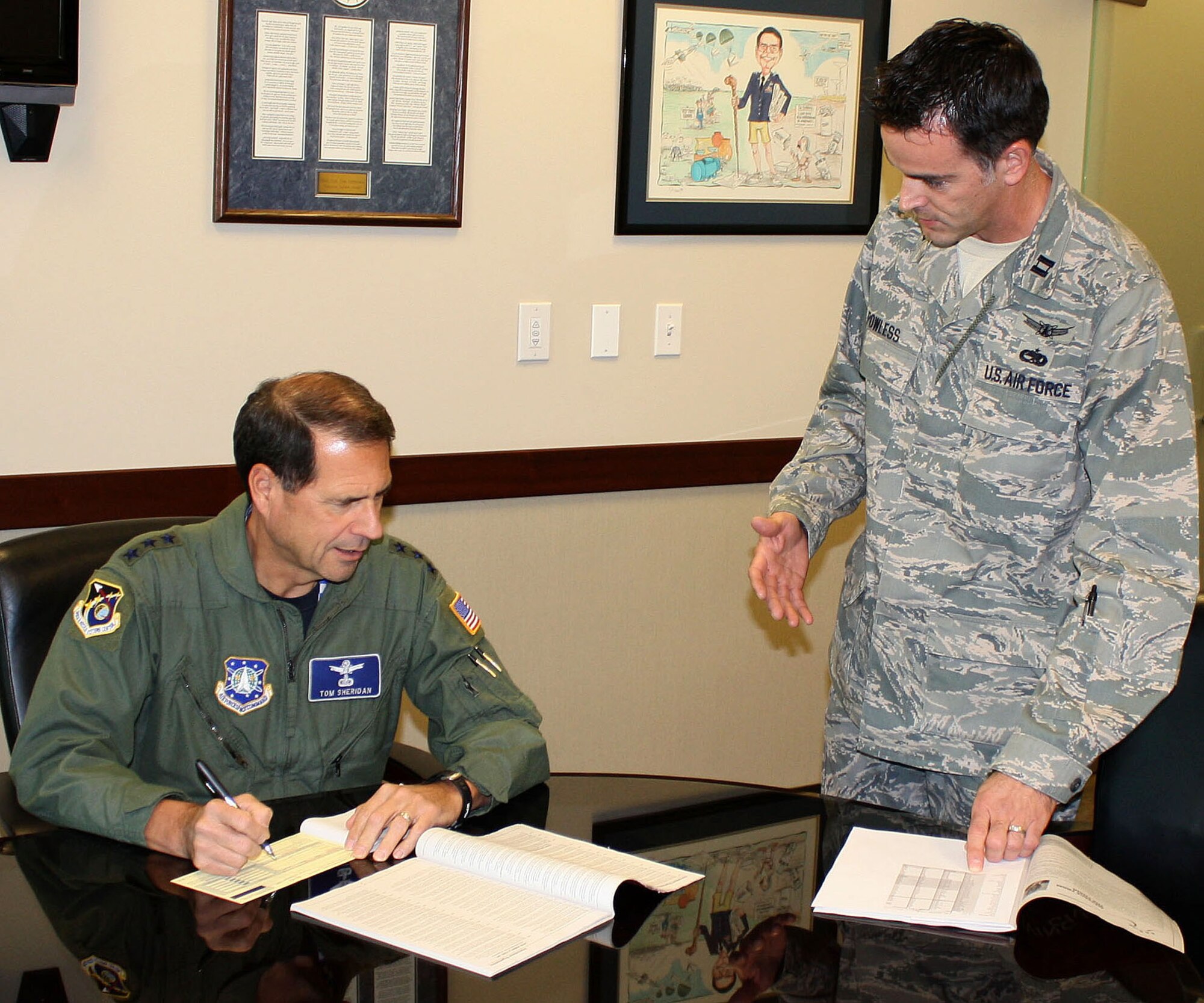 Lt. Gen. Tom Sheridan (left), Space and Missile Systems Center commander, fills out his 2009 Combined Federal Campaign contribution form, as CFC project officer Capt. Justin Powless, SMC Program and Integration, looks on, Dec. 4. As of week 4, the Los Angeles Air Force Base has made 100 percent contact and raised 51 percent of the contribution goal. This year’s CFC campaign began Nov. 4 and ends on Dec. 15. For further information, contact Captain Powless at 310-653-1269. (Photo by 1st Lt. Matt Nelson)