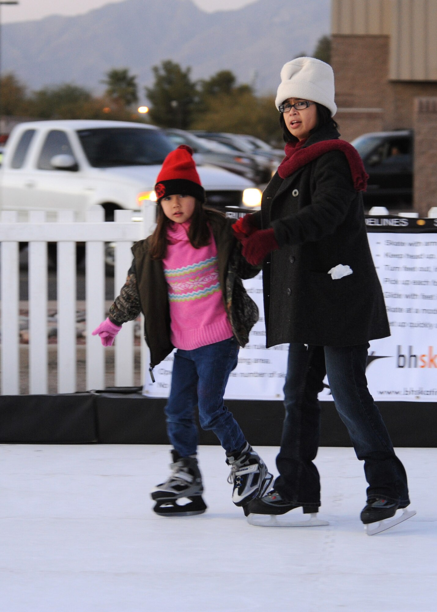 Liz Burke and her 5-year-old daughter, Adina Burke, family of Tech. Sgt. Matthew Burke, 755th Aircraft Maintenance Squadron, skate hand-in-hand during the 5th annual Starry Snowy Night event here Dec. 8. Hosted by the 355th Fighter Wing Commander, Brig. Gen. Paul Johnson, and the 355th Force Support Squadron, this event was open to all base members and their families. In addition to 50 tons of snow, there were hay rides, pictures with Santa and ice skating for everyone to celebrate the holiday season. (U.S. Air Force photo/Airman Jerilyn Quintanilla)
