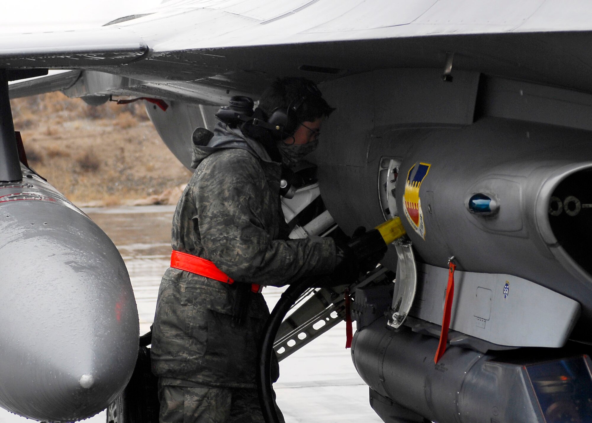 BAGRAM AIRFIELD, Afghanistan -- Airman 1st Class Ryan Macz, an electrician/environmental specialist from the 455th Expeditionary Aircraft Maintenance Squadron, begins keying an F-16 Fighting Falcon Dec. 10, 2009.  Keying the aircraft allows the fighters to stay in contact with each other as well as the command post without interruptions.  Airman Macz is deployed from Shaw Air Force Base, S.C., and hails from Coeur D'Alene, Idaho.  (U.S. Air Force photo/Senior Airman Felicia Juenke)