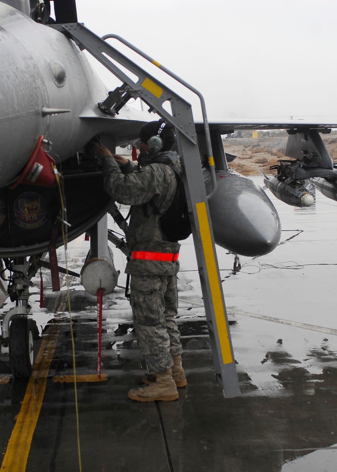 BAGRAM AIRFIELD, Afghanistan -- Airman 1st Class Phillip Souphanthavong, an avionics specialist from the 455th Expeditionary Aircraft Maintenance Squadron, performs a preflight inspection on an F-16 Fighting Falcon Dec. 10, 2009.  The maintenance Airmen perform inspections to assure the aircraft functions properly and safely.  Airman Souphanthavong is deployed from Shaw Air Force Base, S.C., and hails from Raleigh, N.C.  (U.S. Air Force photo/Senior Airman Felicia Juenke)