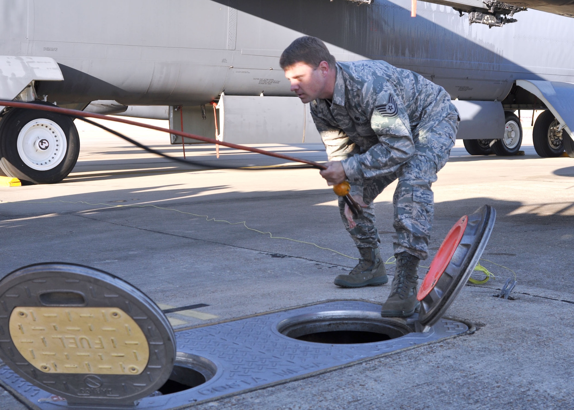 Tech. Sgt. Jayson Kennedy, a fuels technician for the 917th Wing at Barksdale Air Force Base, La., pulls sensor lines from an R-12 hydrant refueling vehicle and moves them towards the sensing valve, which sends a signal to a pump house that the valve is ready to be utilized. The pump house, a storage unit on base, will receive the signal, regulate pressures for the fuel and act as a safety feature while Sergeant Kennedy moves the jet fuel from the main valve to his refueling vehicle. (U.S. Air Force photo/Senior Airman Crystal Jordan)