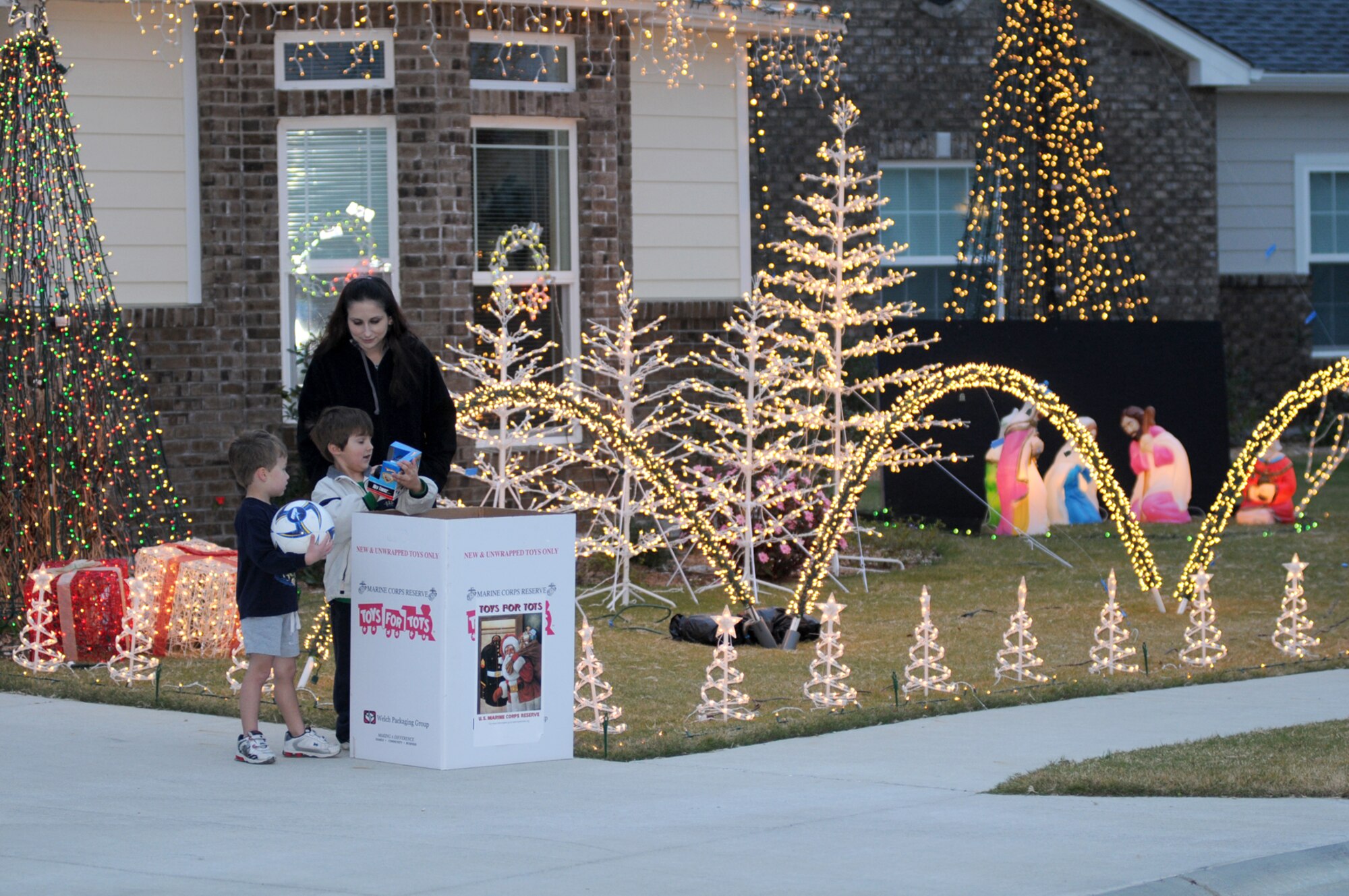 Two years ago, David Solomon, 4, son of Lt. Col. Scott and Devalynn Solomon, watched Tech. Sgt. Charissa Rotundo and her 5-year-old son, Vinny, put a donation in the Toys for Tots collection box at the Solomon home.  At that time, Solomon commanded the 333rd Training Squadron and Rotundo was an instructor in the 336th TRS.   Solomon is now the 81st Training Group's deputy commander and Rotundo is now assigned to Lackland Air Force Base, Texas. The musical light display and toy collection at the Solomon home, 703 Vandenberg Drive in Bay Ridge housing area, is from dark until 10 p.m. Friday, Saturday and Sunday.  (U.S. Air Force photo by Kemberly Groue)
