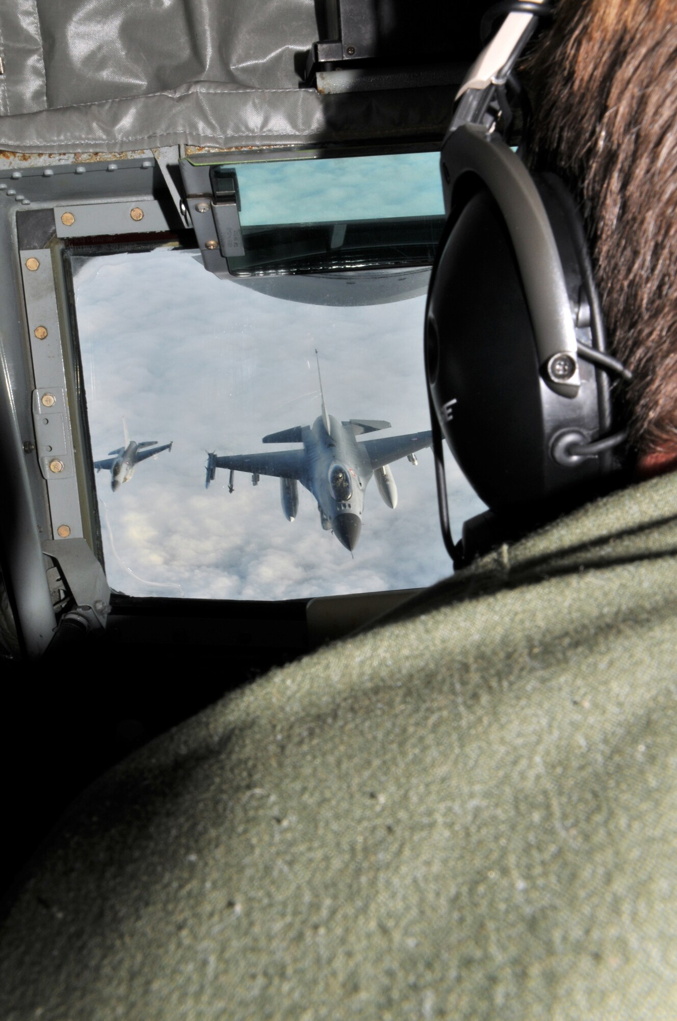 Chief Master Sgt. Christopher Powell, 100th Operations Group boom operator, prepares a KC-135 Stratotanker boom pod as a Royal Danish Air Force F-16 Fighting Falcon positions itself to take on fuel in the skies above Denmark Dec. 8. The Danish F-16 was one of 30 performing their semi-annual aerial refueling training. (U.S. Air Force photo/Tech. Sgt. Kevin Wallace)