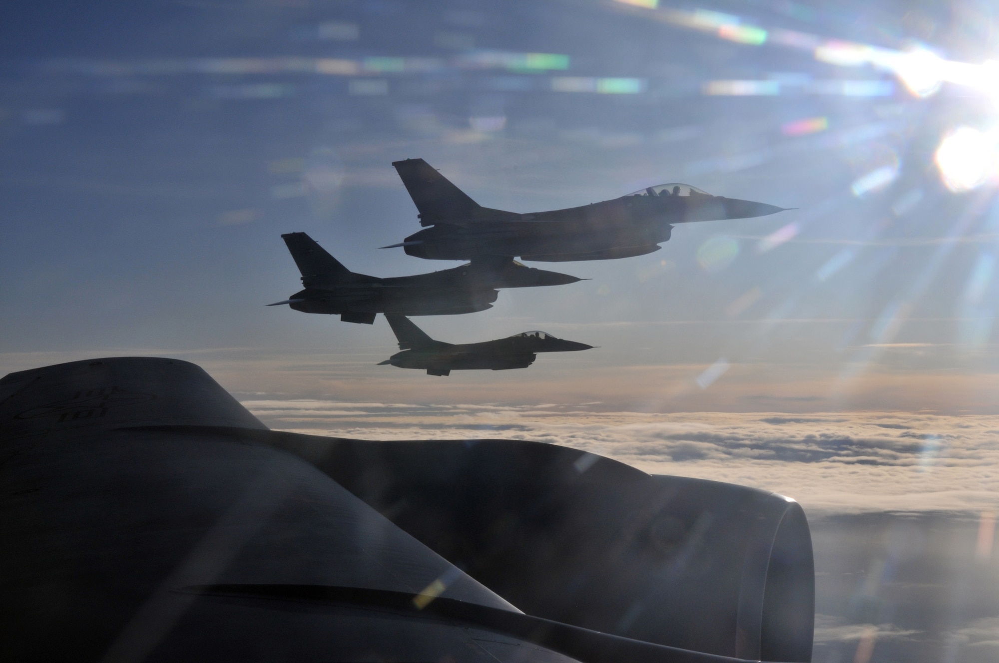 Three Royal Danish Air Force F-16 Fighting Falcons fly off the wing of a KC-135 Stratotanker during a refueling mission over their homeland Dec. 8. The RAF Mildenhall-based Stratotanker refueled 30 aircraft and pumped more than 40,000 tons of fuel in the mission. (U.S. Air Force photo/Tech. Sgt. Kevin Wallace)