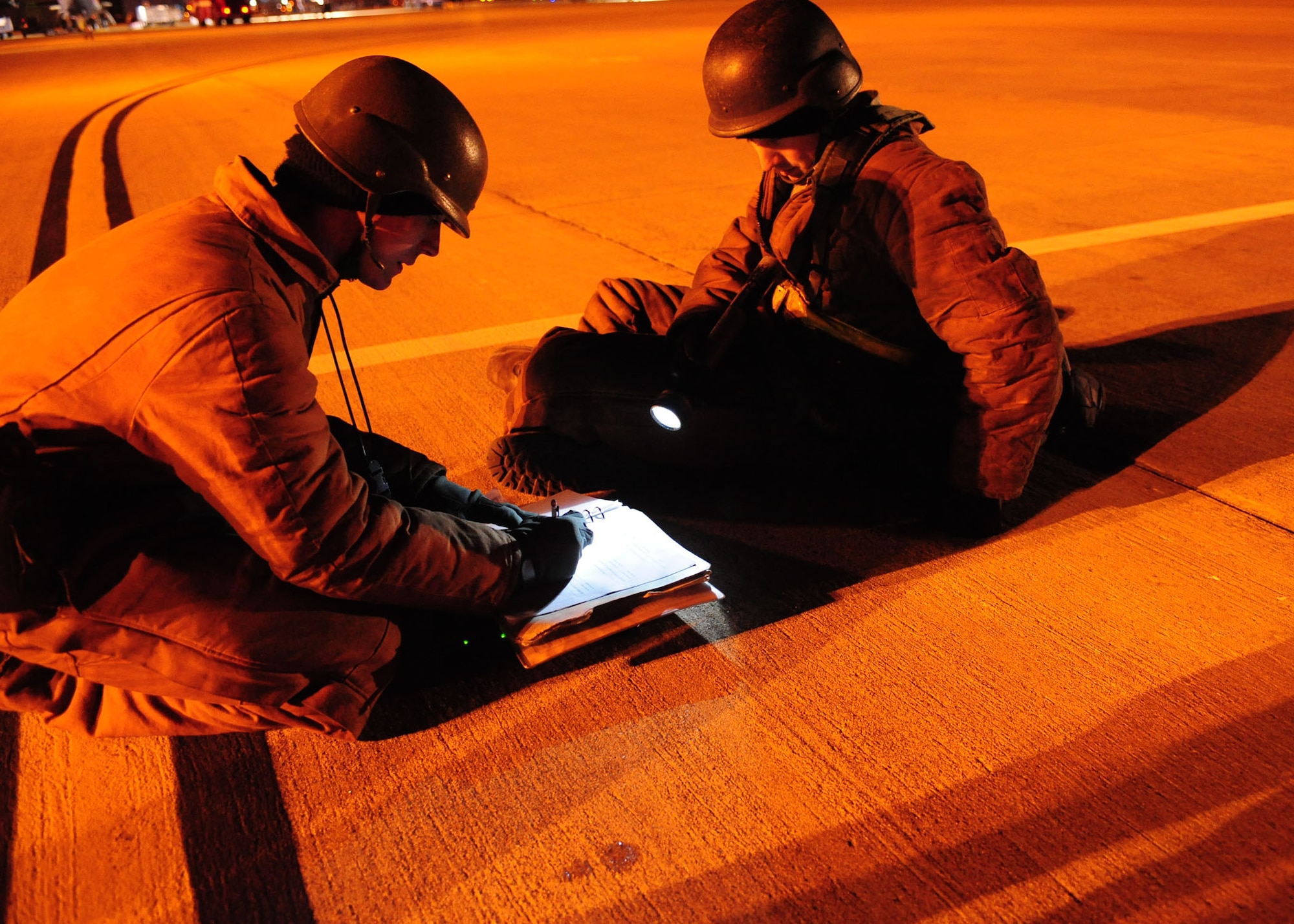 Airman 1st Class Matthew Turco and Senior Airman Justin Hamby, both assigned to the 2d Aircraft Maintenance Squadron, discuss and annotate information on an aircraft form during a conventional operational readiness inspection Dec. 9.  Airmen work around the clock to re-generate B-52H Stratofortresses at Base X, a simulated forward operation location, as part of an inspection to determine the bases readiness to rapidly deploy assets and personnel anywhere in the world. (U.S. Air Force photo by Staff Sgt. Sarah E. Stegman)(RELEASED)
