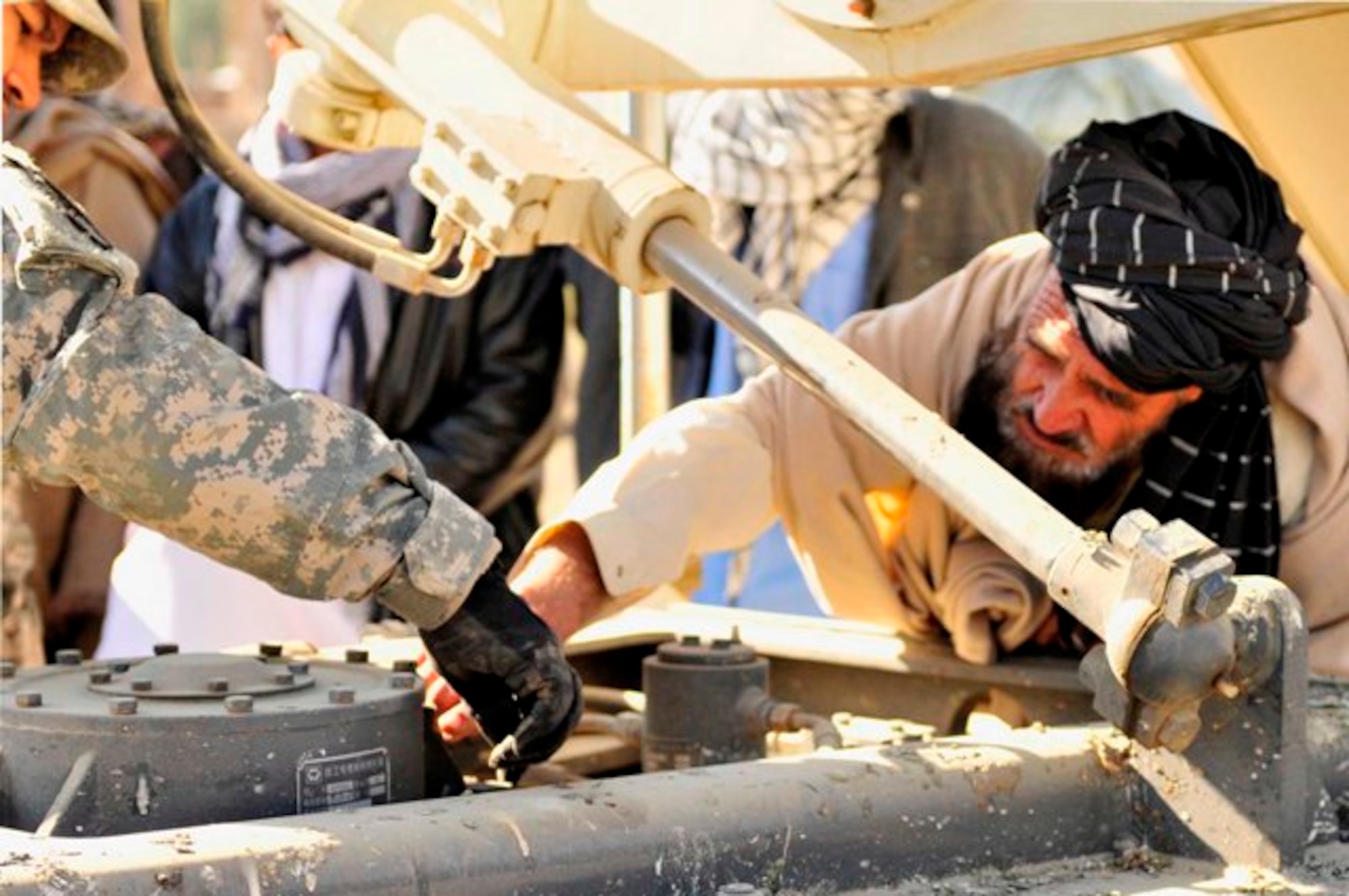 KHOST PROVINCE, Afghanistan – A Khost Public Works operator shows Khost Public Works staff members how to properly perform pre-operational checks during an equipment maintenance course at the Khost City Maintenance Yard in Matun District, recently. (U.S. Air Force photo/Capt. Angela Webb)