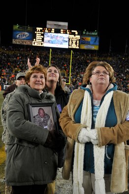 Theresa Murray holds a picture of her husband, Lt Col David Murray, a nurse practitioner with the 115th Fighter Wing as she stands with her four daughters Jennifer Murray-Alston, Staff Sgt. Jamie Murray, Kelly McMeans and Staff Sgt Julie Murray during a Packers Monday Night Football game Dec 7.  The Packers honored the Murray’s at half-time with a video message from Col. Murray, who is currently deployed in Iraq. (U.S. Air Force photo by Tech. Sgt. Don Nelson)