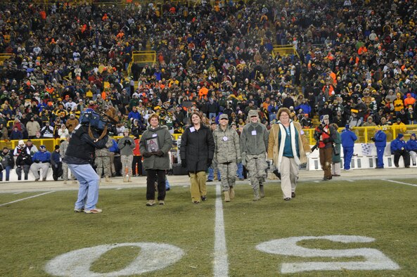 The Green Bay Packers honored military families during their recent Monday Night Football game against the Baltimore Ravens. The Murray family was recognized at half-time on the 50-yard line at Lambeau Field and was surprised by a personal message from Lt. Col. David Murray, a nurse practitioner with the 115th Medical Group deployed to Balad Air Base, Iraq as a flight commander of the intermediate care ward at the Balad Theatre Hospital. Theresa Murray holds a picture of her husband, David and attended the game with her four daughters (left to right) Kelly McMeans, Staff Sgt. Jamie Murray, Staff Sgt. Julie Murray and Jennifer Murray-Alston who are all combat veterans, two of which are current members of the 115th FW. (U.S. Air Force photo by Tech. Sgt. Don Nelson)
