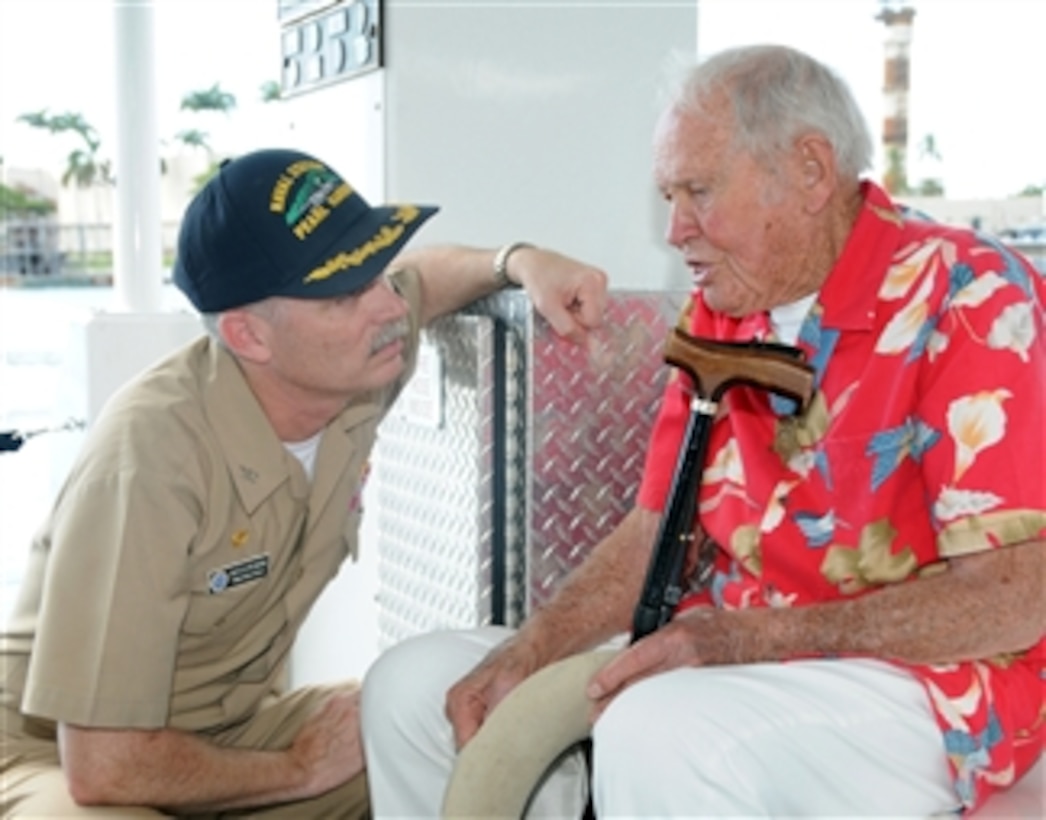 Retired U.S. Navy Lt. John W. Finn speaks with Capt. Richard Kitchens, commanding officer of Naval Station Pearl Harbor, during Finn's trip to see the USS Arizona Memorial aboard the White Boat bearing his name on Dec. 6, 2009.  Finn, the oldest living Medal of Honor recipient, was awarded the Medal of Honor for heroism during the Japanese attack on Pearl Harbor on Dec. 7, 1941.  