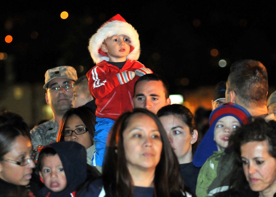 Onlookers observe as Col. Anita Latin, 61st Air Base Wing commander, reads a holiday story during the annual Tree Lighting Ceremony held at Fort McArthur, Dec. 4. Other festivities included a visit from Santa, snow day with children's play area covered with more than 20 tons of man-made snow and two 50-ft. sled runs. (Photo by Atiba S. Copeland)