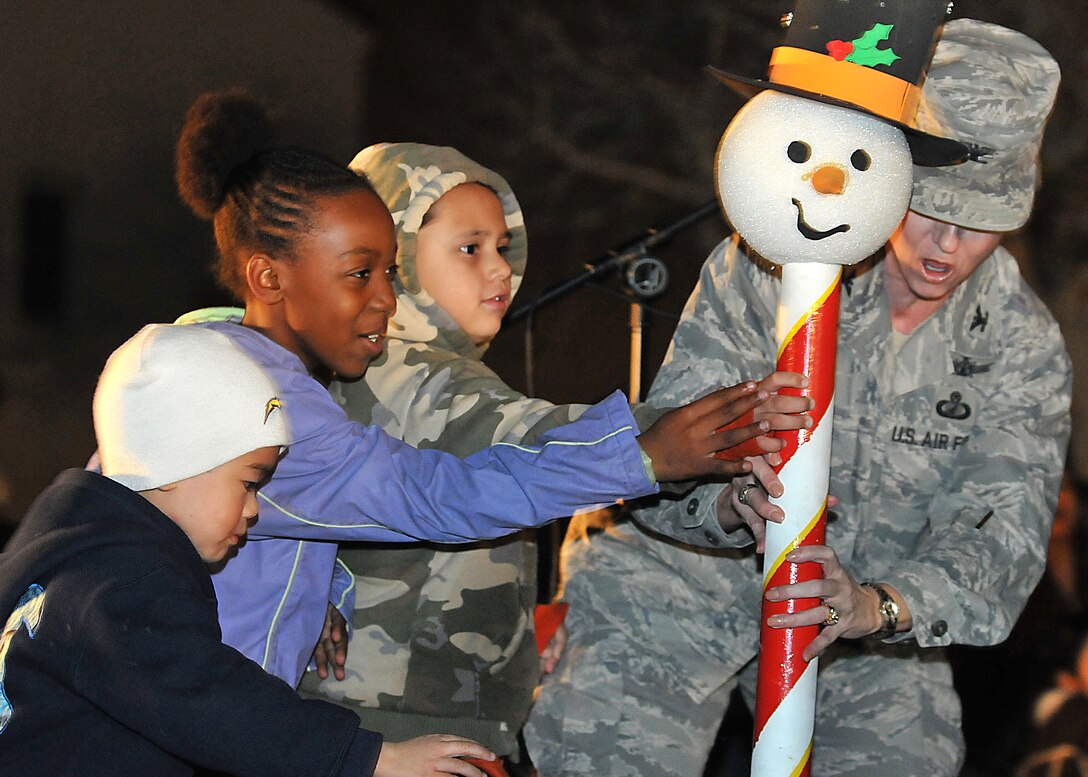 Col. Anita Latin, 61st Air Base Wing commander, with help from some children, switch on the lights to Fort McArthur’s Christmas tree during the annual Tree Lighting Ceremony, Dec. 4. Other festivities included a visit from Santa, snow day with children's play area covered with more than 20 tons of man-made snow, two 50-ft. sled runs and a holiday story reading by Colonel Latin. (Photo by Atiba S. Copeland)