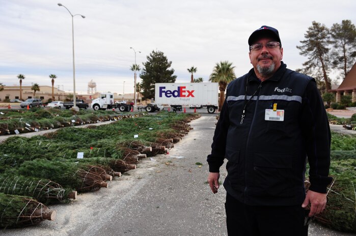 NELLIS AIR FORCE BASE, Nev.-- Tony Petralia, FedEx driver and former aggressor squadron crew chief, helped bring hundreds of Christmas trees to Nellis and Creech Airmen for the Trees for Troops program, Dec. 11. Trees for Troops is sponsored by the Christmas SPIRIT Foundation and FedEx Corp.  "This is the first time I have delivered Christmas trees to a base where I served on active duty," said Petralia.  Mr. Petralia was stationed at Nellis from 1979-1983. This year, 15,000 trees from 29 states are expected to be delivered to military bases in the United States and overseas. 
(U.S. Air Force Photo / Staff Sgt. William P. Coleman)