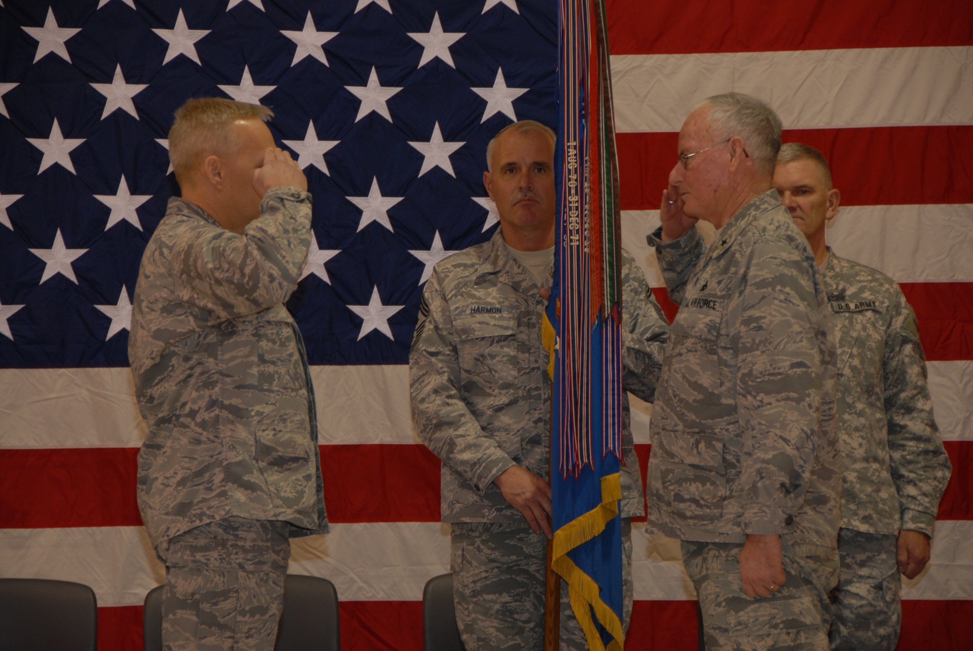 Col. Rick Gibney salutes Brig.Gen. Alan Palmer during a Change of Command Ceremony as Chief Master Sgt. David Harmon holds the N.D. Flag.  The ceremony  took place at the North Dakota Air National Guard on Dec. 5th.  Col. Robert Becklund relinquished command of the 119th Wing to Col. Rick Gibney during the ceremony.