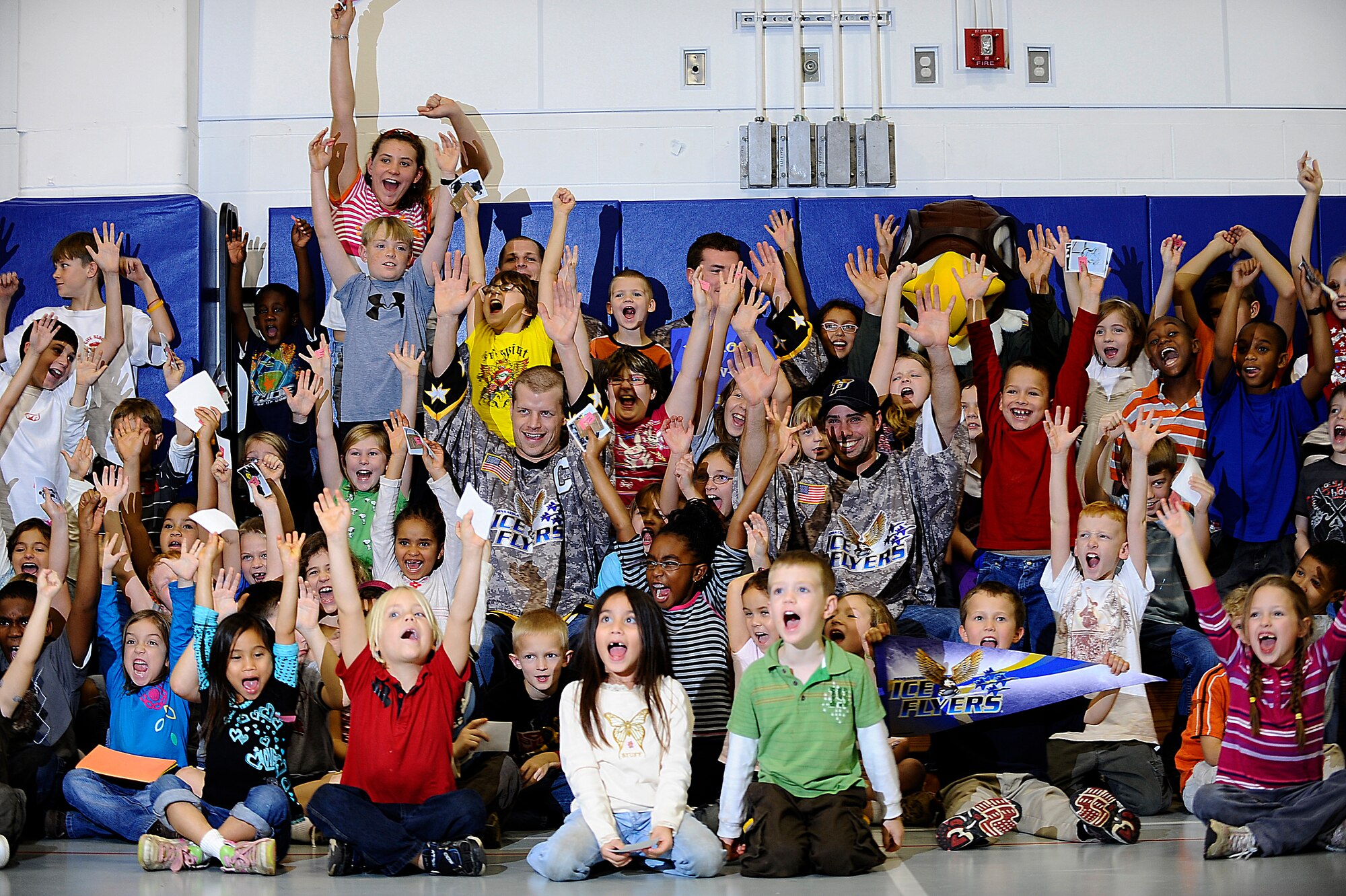 Members of the Pensacola Ice Flyers pose for a group photograph with children from the Youth Center during their visit to Hurlburt Field Dec. 9. The Ice Flyers, a Southern Professional Hockey League expansion team, were also here to promote interest in the sport among those in attendance. (Air Force photo by Senior Airman Julianne Showalter)