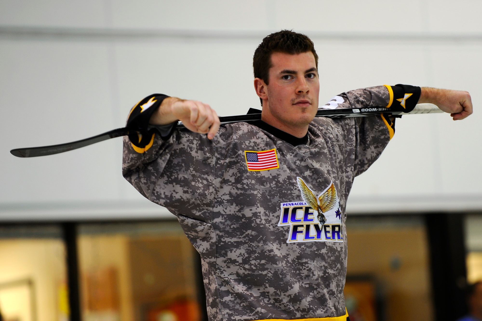 Chris Rebernik from the Pensacola Ice Flyers watches children from the Youth Center hit hockey pucks Dec. 9 Hurlburt Field. The Ice Flyers also handed out autographs and tickets to upcoming games in a ticket raffle. The Ice Flyers, a Southern Professional Hockey League expansion team, were also here to promote interest in the sport among those in attendance. (Air Force photo by Senior Airman Julianne Showalter)