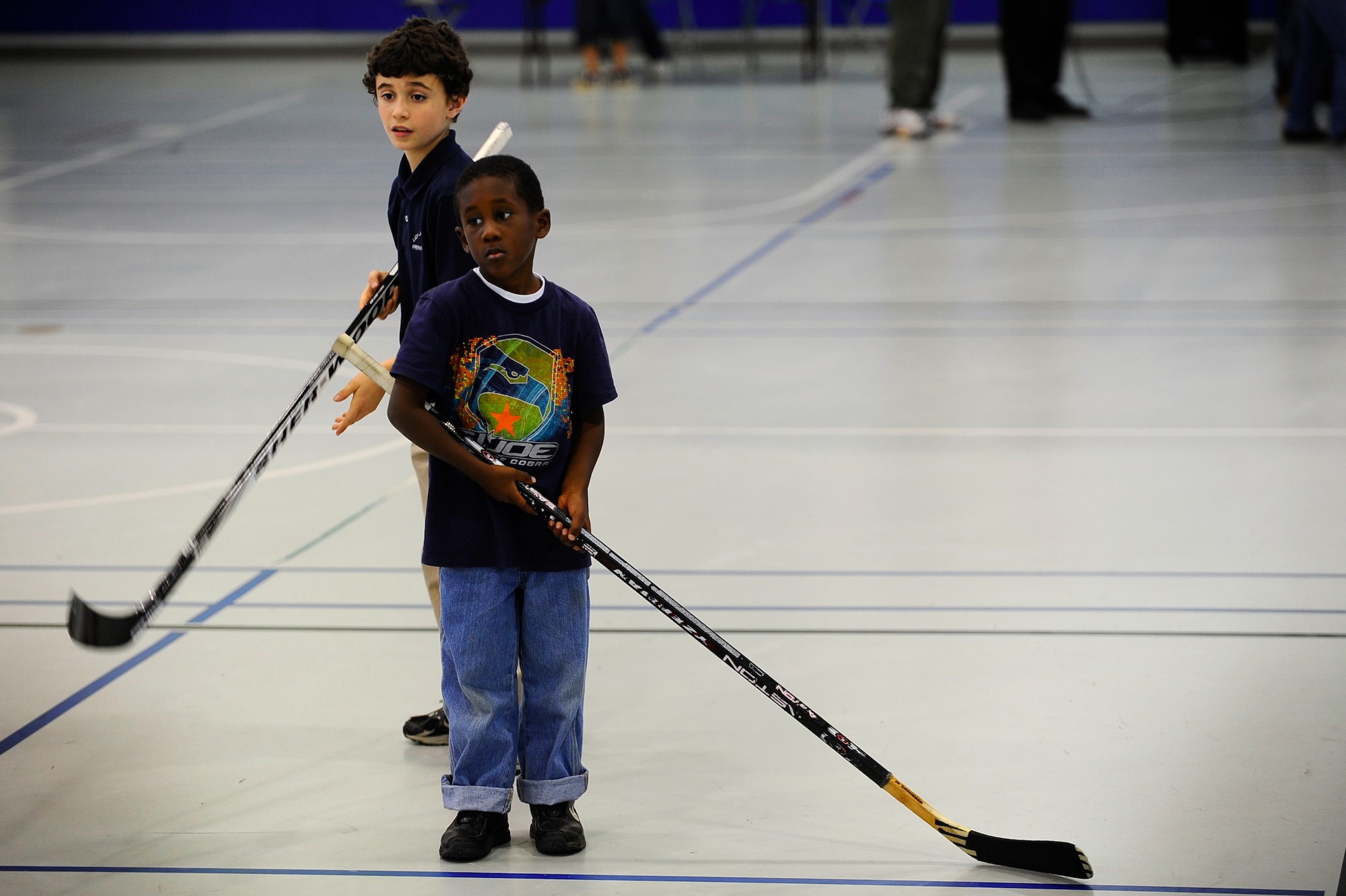 Calvin Stubbs, front, 6, and Alex Parsley, back, 9, stand in line to hit hockey pucks during the Pensacola Ice Flyers’ visit to the Hurlburt Field youth center Dec. 9. The Ice Flyers, a Southern Professional Hockey League expansion team, were also here to promote interest in the sport among those in attendance.(Air Force photo by Senior Airman Julianne Showalter)