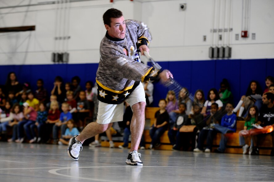 Chris Rebernik from the Pensacola Ice Flyers demonstrates how to hit a wrist-shot for dozens of children during their visit to Hurlburt Field youth center Dec. 9. The Ice Flyers, a Southern Professional Hockey League expansion team, were also here to promote interest in the sport among those in attendance. (Air Force photo by Senior Airman Julianne Showalter)