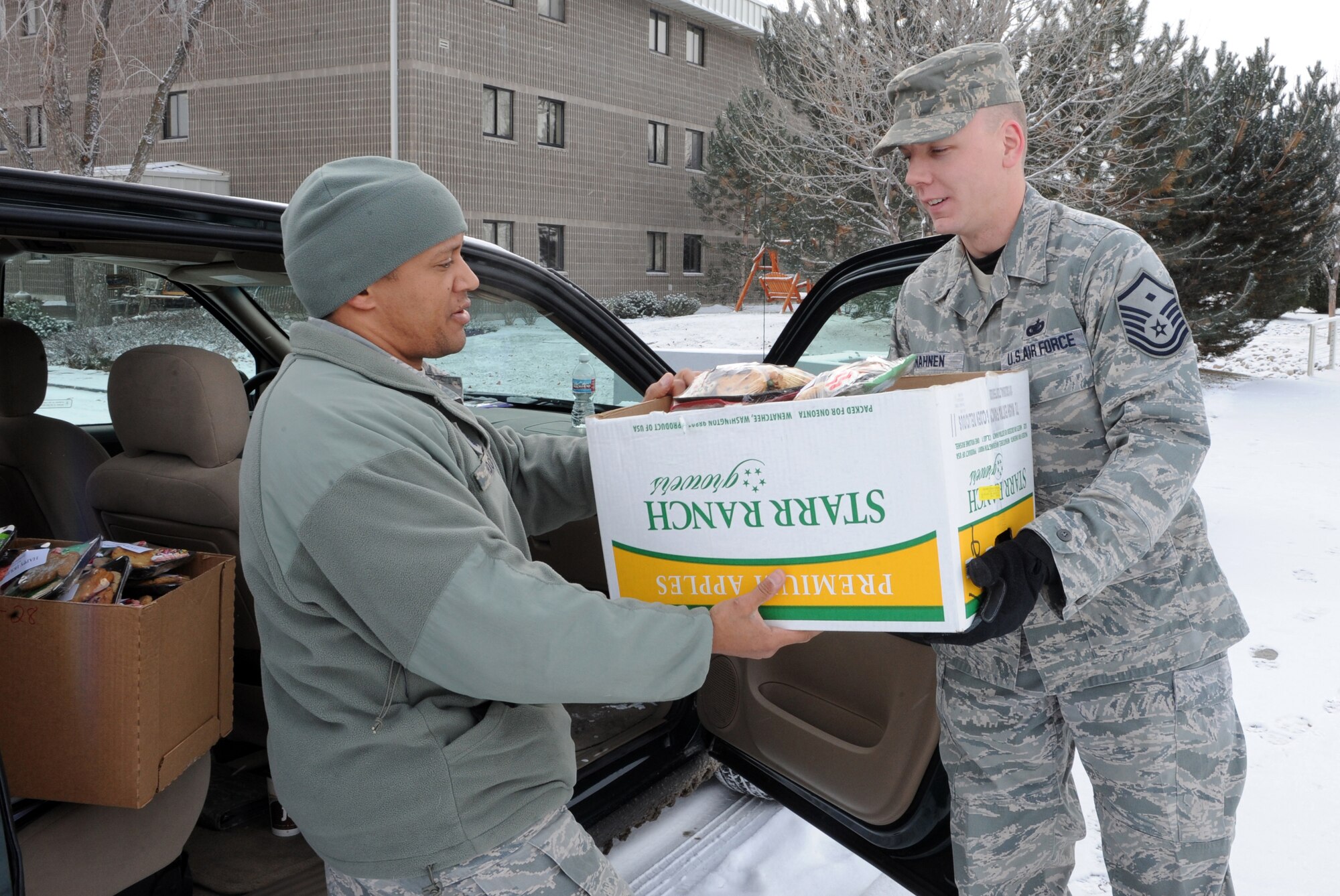 MOUNTAIN HOME AIR FORCE BASE, Idaho -- Master Sgt. Charles Hooks, 390th Aircraft Maintenance Unit first sergeant, hands a box of packaged cookies to Master Sgt. Michael Vonahnen, 391st Aircraft Maintenance Unit first sergeant, as they prepare to deliver cookies to dorm residents Dec. 7. The 366th Fighter Wing's Annual Holiday Cookie Drive takes place during the first part of December to provide the base’s dorm residents a comforting taste of home in the form of a dozen cookies. (U.S. Air Force photo by Airman 1st Class Debbie Lockhart)