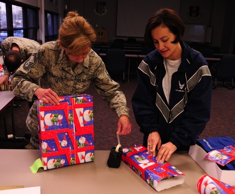NIAGARA FALLS AIR RESERVE STATION, NY--Senior Master Sgt Jeannie Morrison and Master Sgt Melody Yates, 914 Airlift Wing, wrap presents for the Adopt a Family Program which supports families in need throughout the holiday season. (U.S. Air Force photo by Staff Sgt Stephanie Clark)