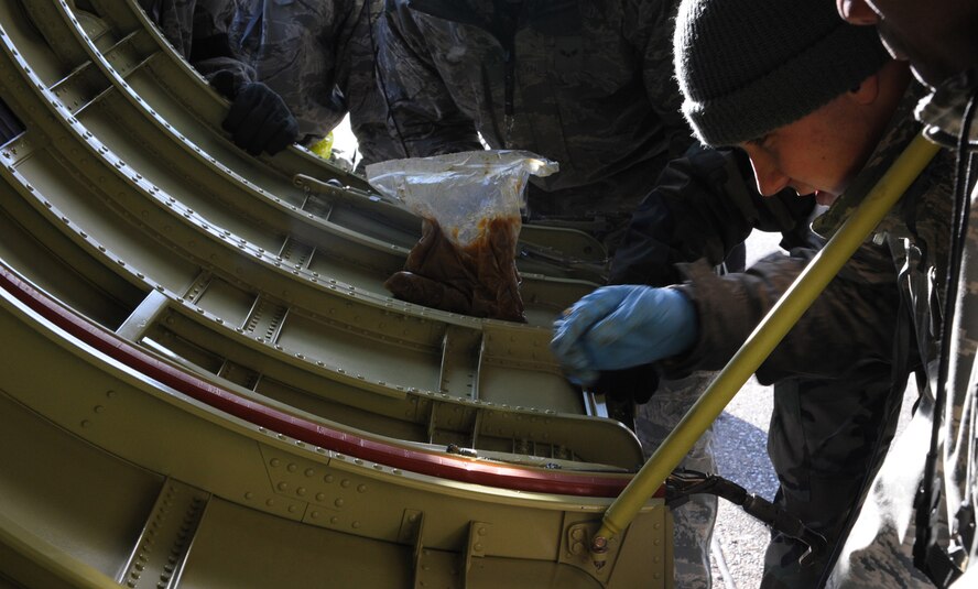 Airman Jake Korthas, 2d Aircraft Maintenance Squadron, applies grease to the locks of a new B-52 engine cowling during a conventional operational readiness exercise at Barksdale. Airmen generated several aircraft to highlight their capability to support global contingency operations. (U.S. Air Force photo by Tech. Sgt. Mike Andriacco) (RELEASED)