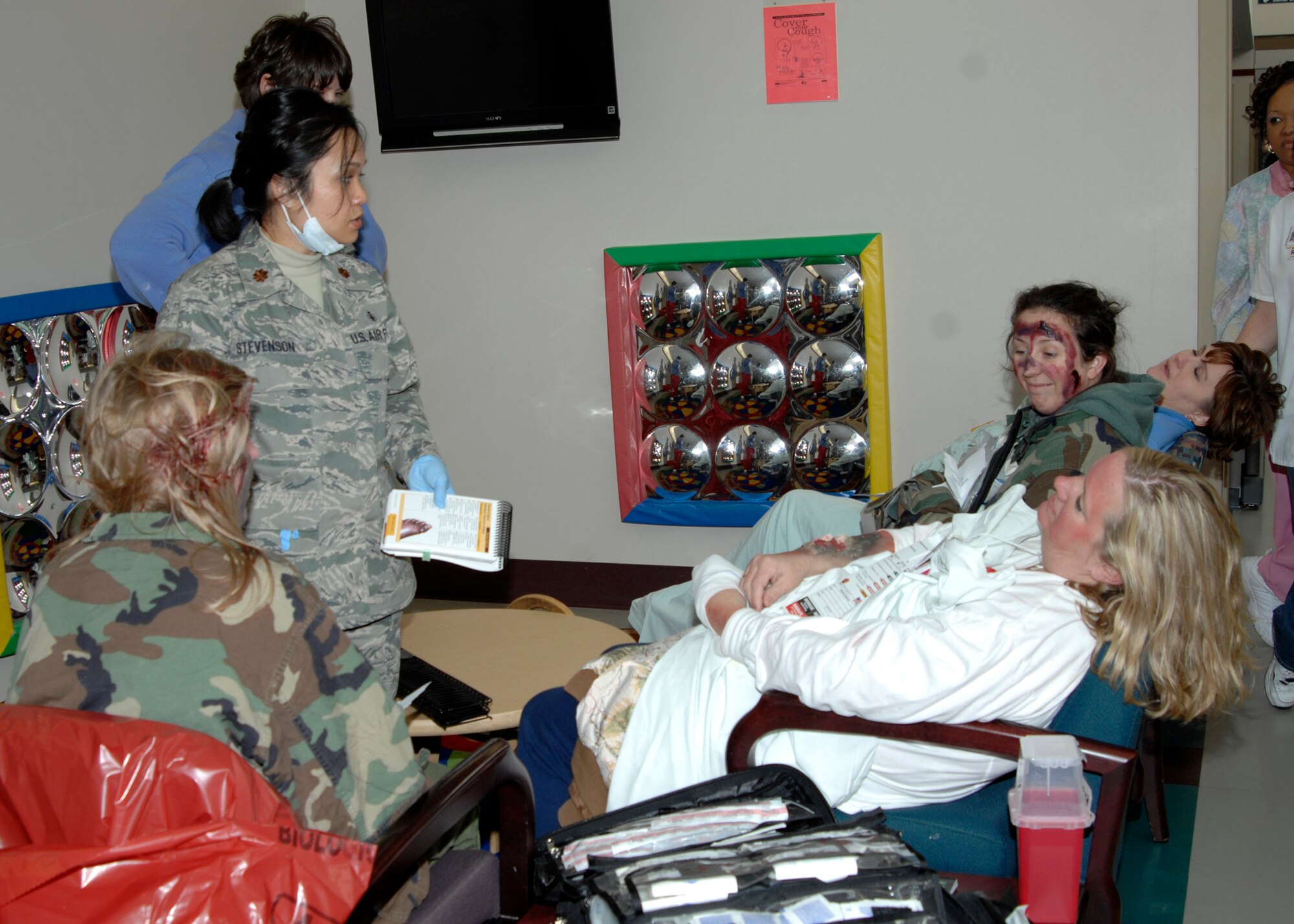 Maj. Bonnie Stevenson, 22nd Medical Operations Squadron, evaluates the condition of “wounded individuals” to determine who is in most urgent need of care during a chemical attack response exercise, Dec. 2, 2009, McConnell Air Force Base, Kan. Maj. Stevenson inspected their symptoms and asked them general questions to get an overview of each individual’s condition. (U.S. Air Force Photo/Airman 1st Class Justin Shelton)