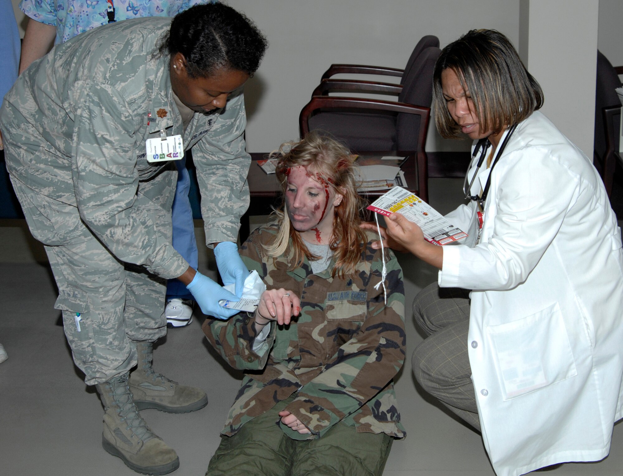 Maj. Vanessa Griffin, left, a registered nurse, and McKellia Dawson, a physician’s assistant, both 22nd Medical Group members, treat Lindsay Smith, a mock chemical attack victim, at the base clinic during a 22nd Medical Group exercise, Dec. 2, 2009, McConnell Air Force Base, Kan. (U.S. Air Force Photo/Airman 1st Class Justin Shelton)