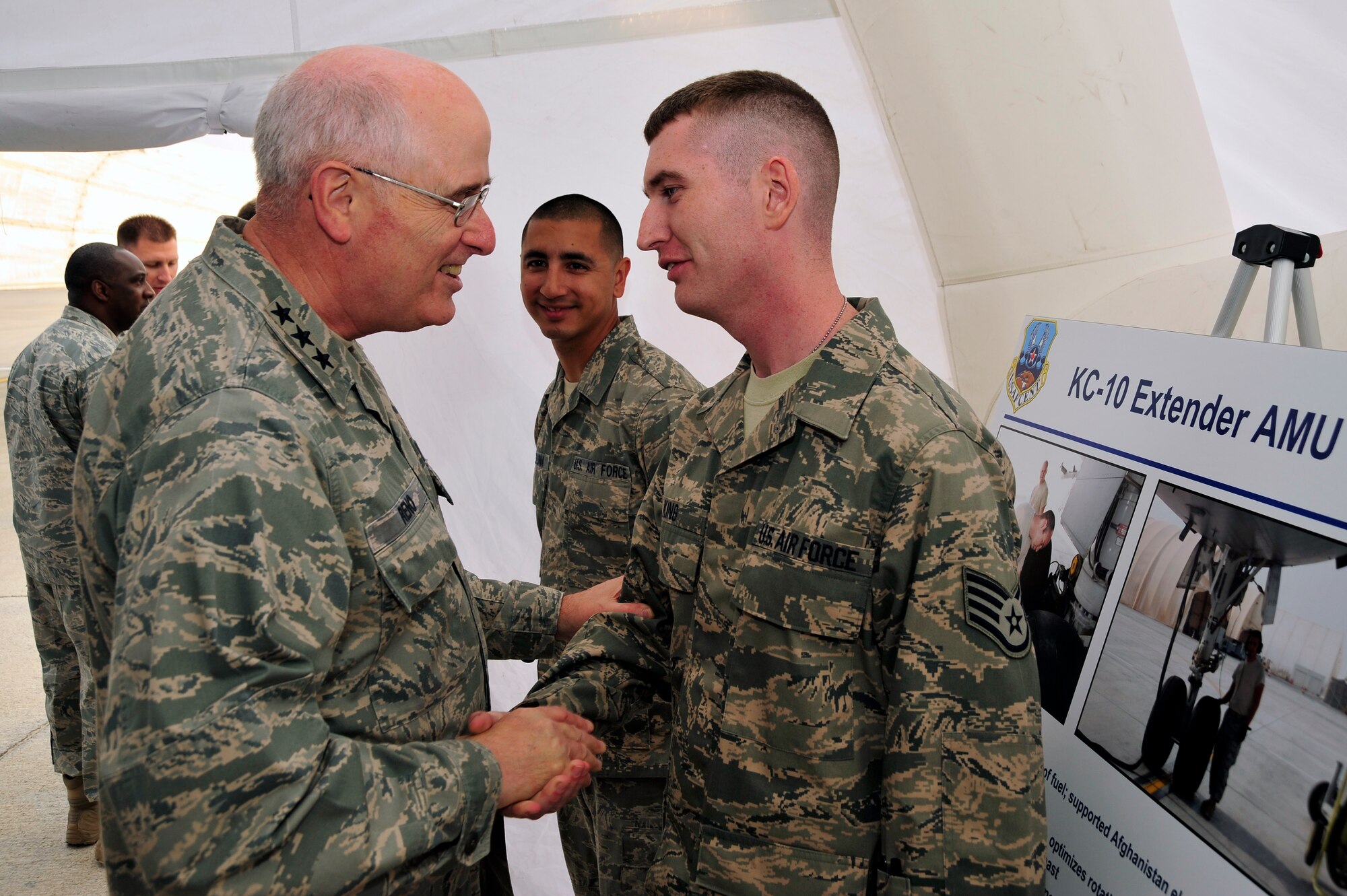 SOUTHWEST ASIA - Lt. Gen. Loren Reno, Deputy Chief of Staff for Logistics, Installations and Mission Support, presents a coin to Staff Sgt. Odis King and Airman 1st Class Daniel Deluna, 380th Expeditionary Aircraft Maintenance Squadron, as a token of gratitude for the briefing given Dec. 10, 2009. Sergeant King and Airman Deluna are deployed from McGuire Air Force Base, N.J., Sergeant King grew up in Mitchell, Ind., and Airman Deluna grew up in San Antonio, Texas. (U.S. Air Force photo/Tech. Sgt. Charles Larkin Sr)