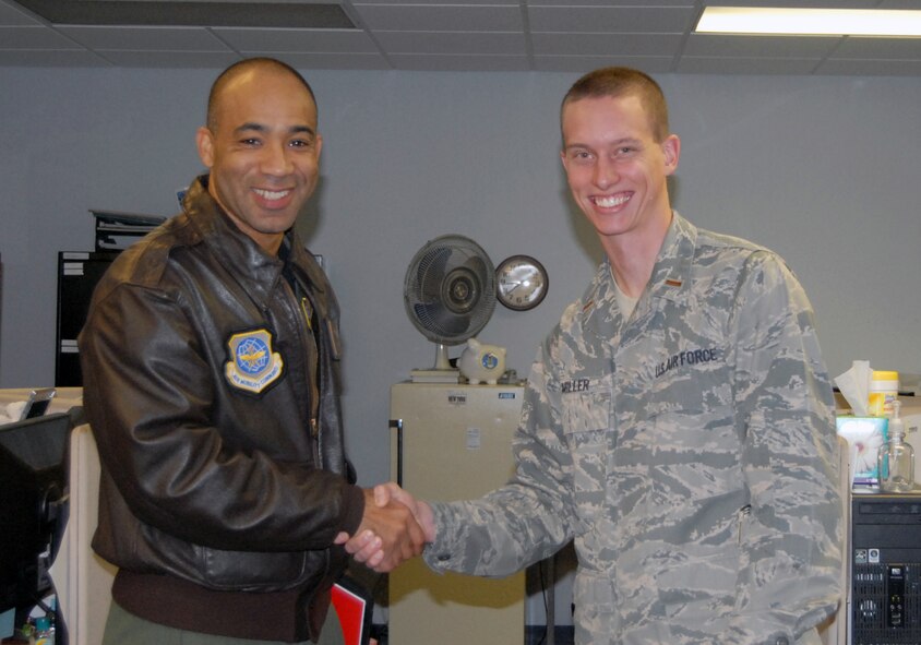 Col. James Johnson, 43rd Airlift Wing Commander, presented 2nd Lt. Matthew Miller, 43rd Comptroller Squadron, a Commander’s Coin Nov. 24. (U.S. Air Force photo by 2nd Lt. Cammie Quinn)