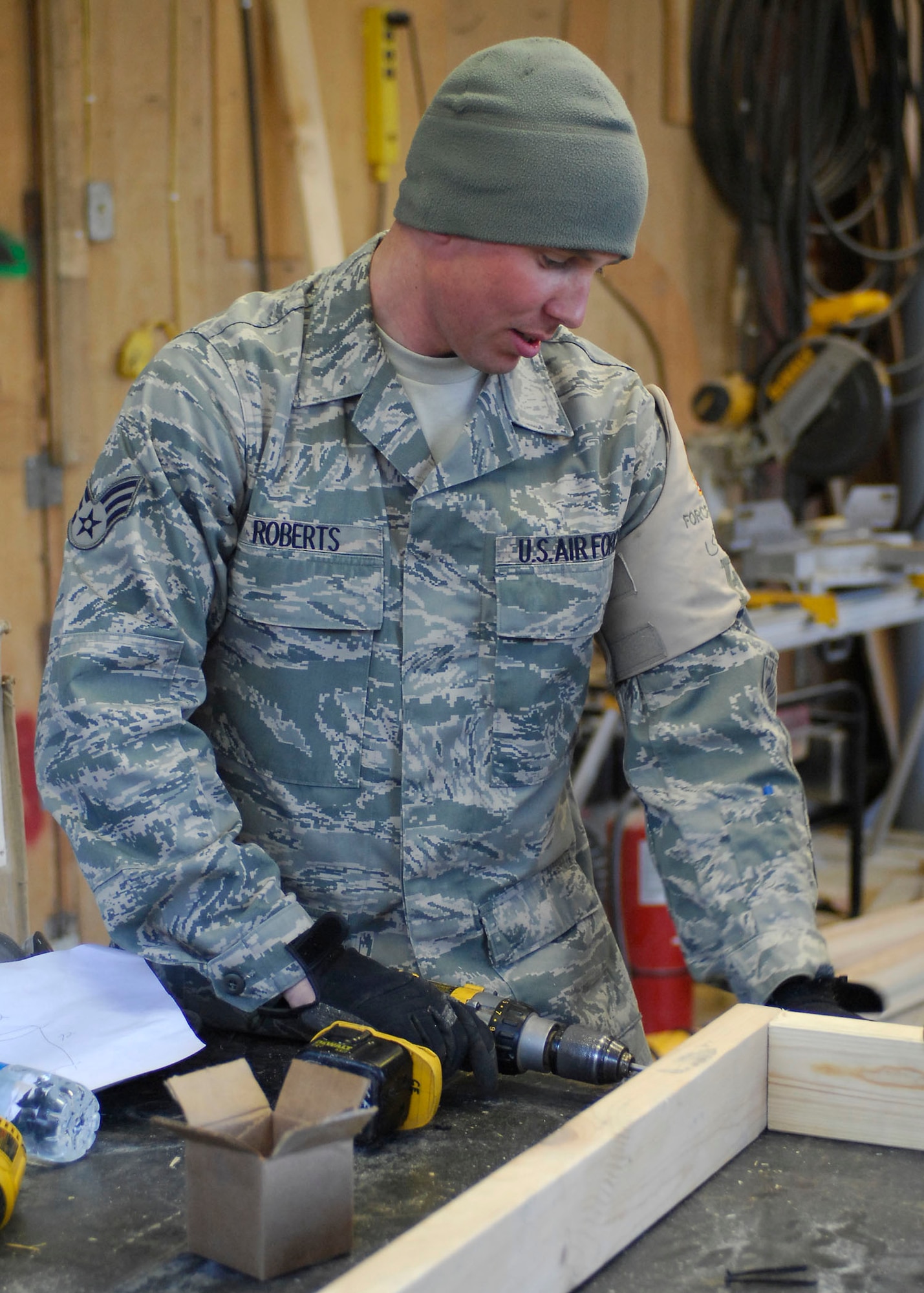 BAGRAM AIRFIELD, Afghanistan -- Senior Airman Matthew Roberts, a force protection Airman from the 455th Expeditionary Civil Engineering Squadron, screws two pieces of plywood together to build shelves for the laundry services office, Dec. 11, 2009.  The shelves will be use to hold laundry waiting to be picked up by the growing population of Airmen.  Airman Roberts is deployed from Elmendorf Air Force Base, Alaska and hails from Hartford, Mich.  (U.S. Air Force photo/Senior Airman Felicia Juenke)