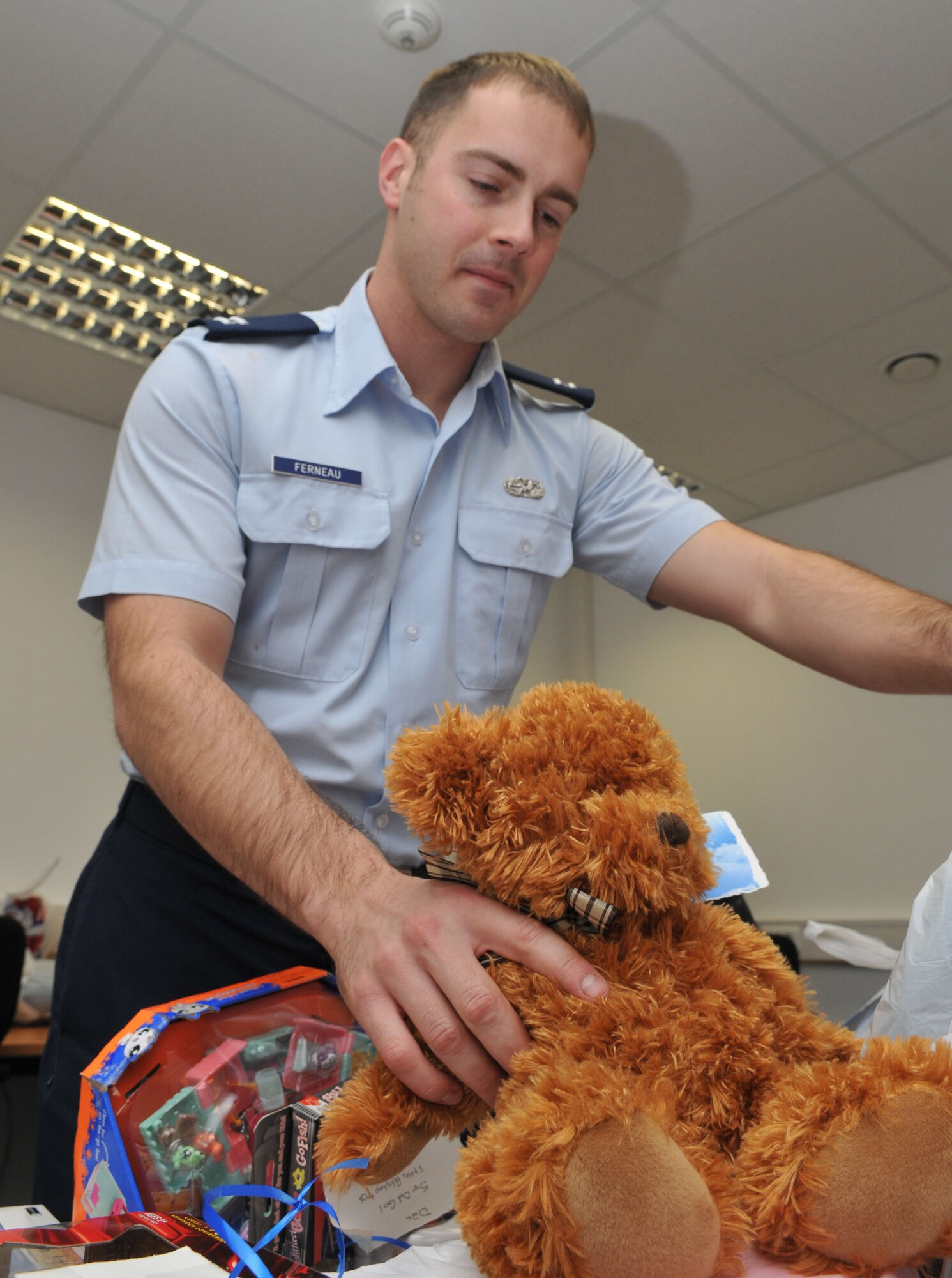 SPANGDAHLEM AIR BASE, Germany -- Capt. Jared Ferneau, 52nd Fighter Wing plans officer, organizes donated gifts for the Angel Tree Program in wing headquarters Dec. 7.  The Angel Tree Program provides gifts to children of servicemembers who need extra assistance during the holidays. As of Dec. 9, the wing raised about $900 for approximately 60 children from 26 families.  Donations are being collected from the Spangdahlem and Bitburg Base Exchanges through Dec. 12. (U.S. Air Force photo/Airman 1st Class Nick Wilson)