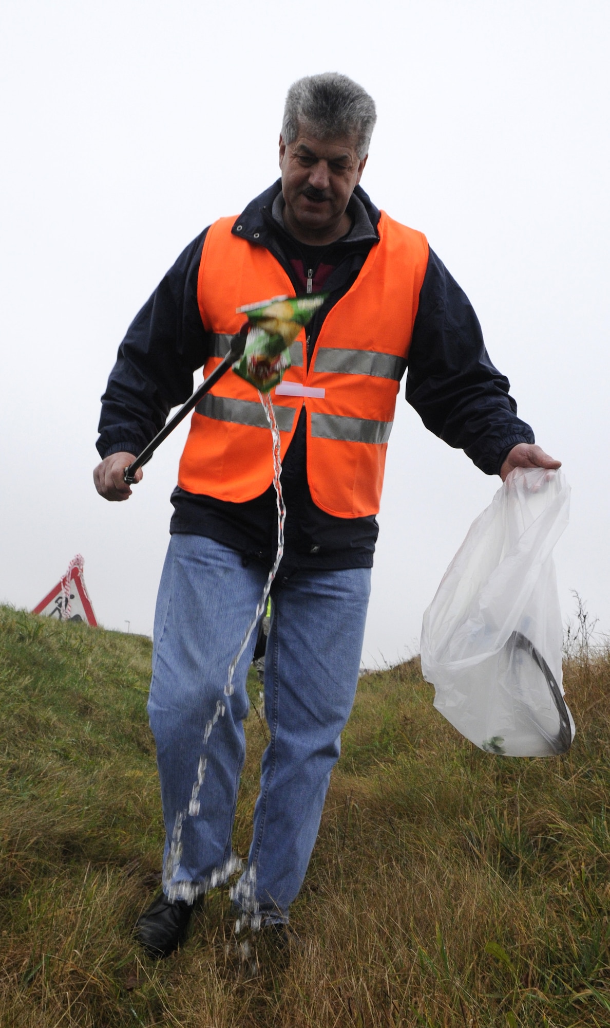 SPANGDAHLEM AIR BASE, Germany –Klaus Rodens, Spangdahlem mayor, assists Eifel Pride Airmen from the 52nd Civil Engineer Squadron clean along the L-46 Dec 8. Eifel Pride will now perform trash clean-up along L-46 between the main gate and gate 2 on a monthly basis. (U.S. Air Force photo/Airman 1st Class Staci Miller)