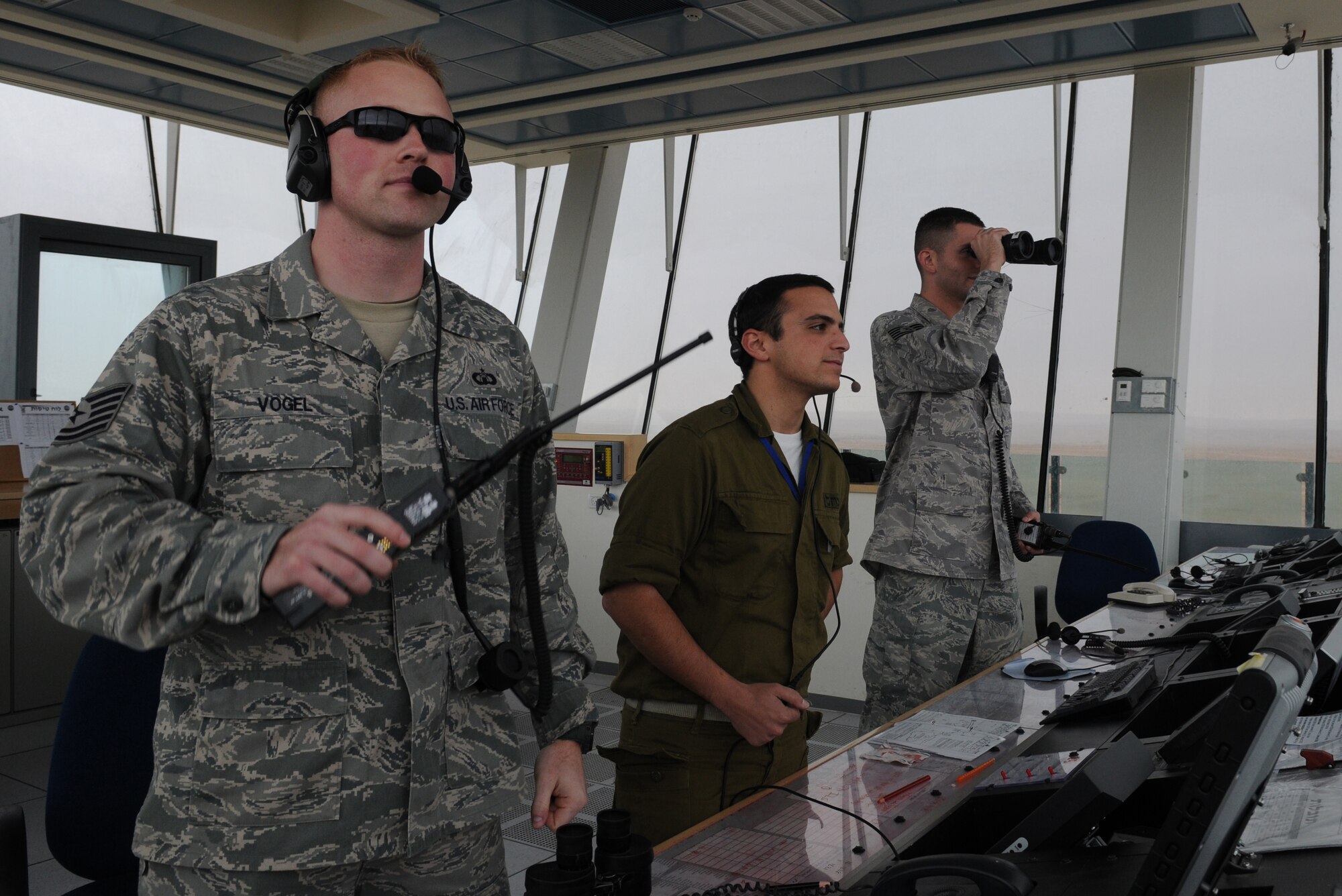 U.S. Air Force Tech. Sgt. Jeff Vogel, 435th Contingency Response Group contingency aircraft controller, Israeli Air Force Eitan Haredim air traffic controller and Tech. Sgt. Shawn Smith, 435th CRG contingency airfield manager, look out on the flightline, Dec. 8, 2009, Nevatim Air Force Base, Israel. The 435th CRG air traffic controllers were the liaison between the Israeli controller and the American mission during the exercise. (U.S. Air Force photo by Airman 1st Class Alexandria Mosness) 